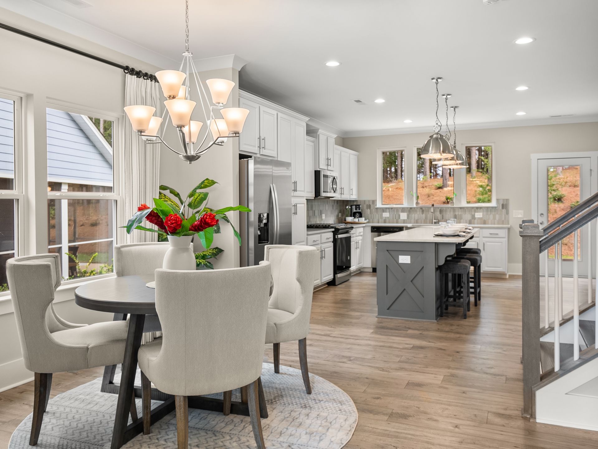 A dining room table and chairs in a kitchen with a chandelier.