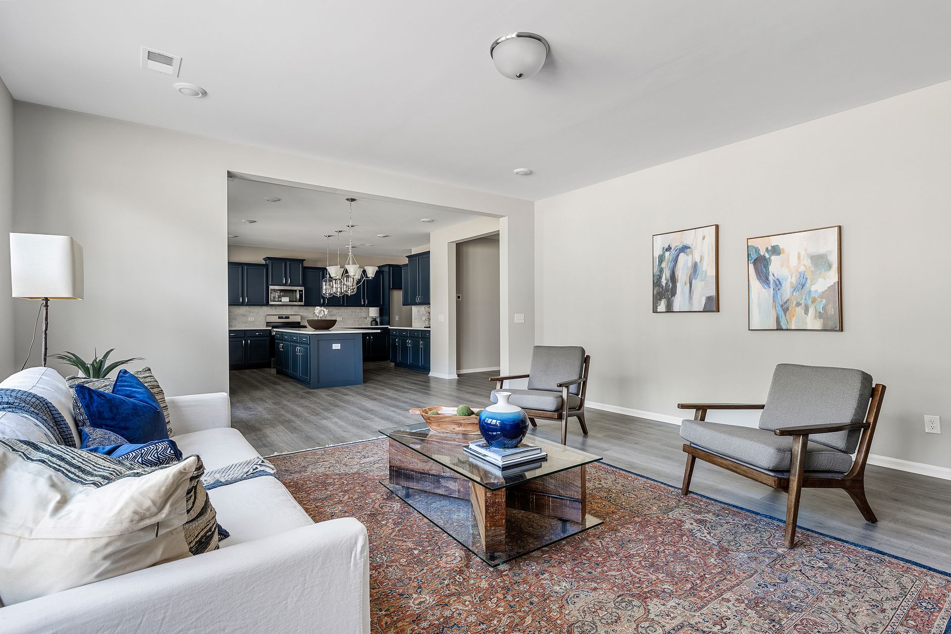 A living room with a couch , chairs , coffee table and rug.