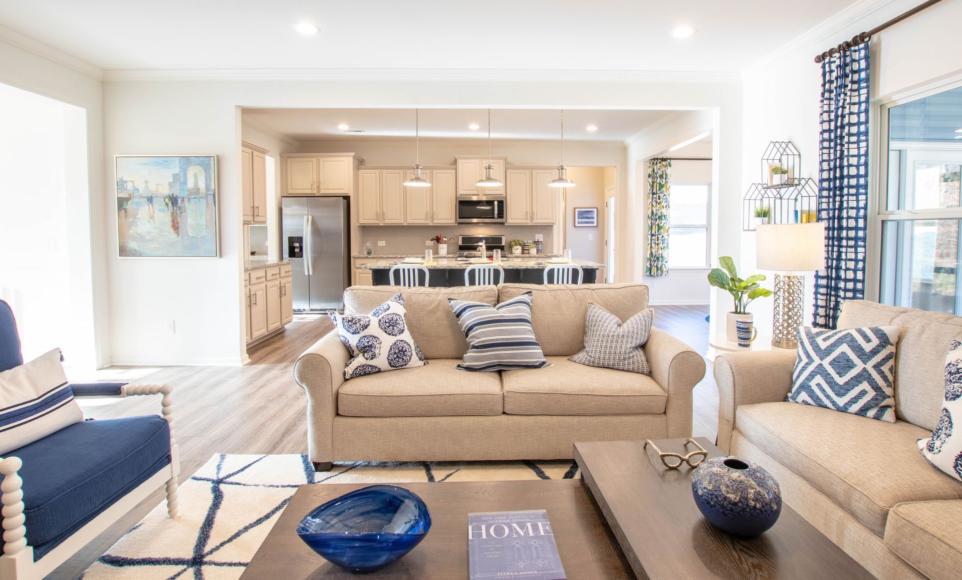A living room with a couch , chair , coffee table , and book.