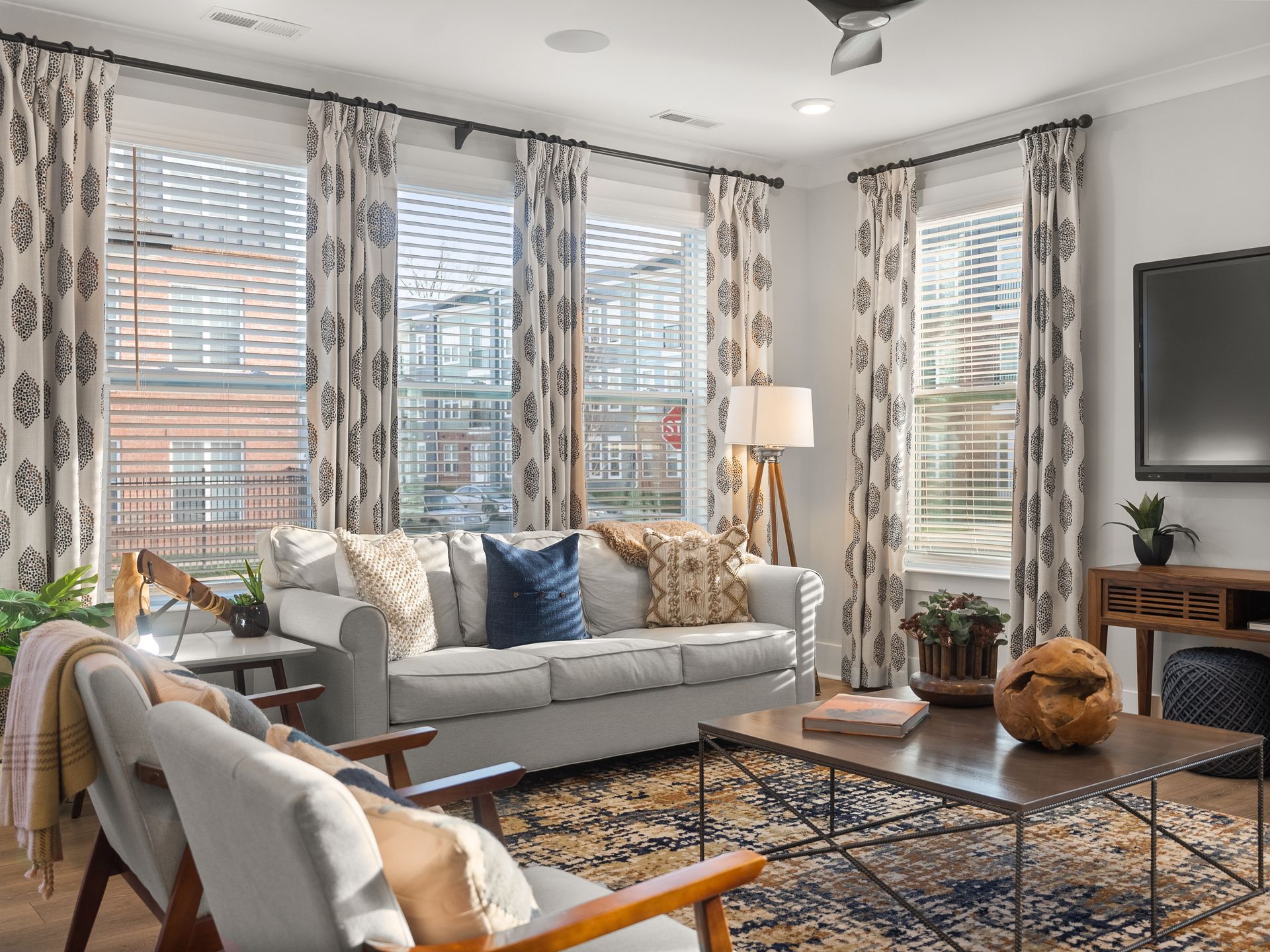A living room with a couch , chairs , coffee table and television.