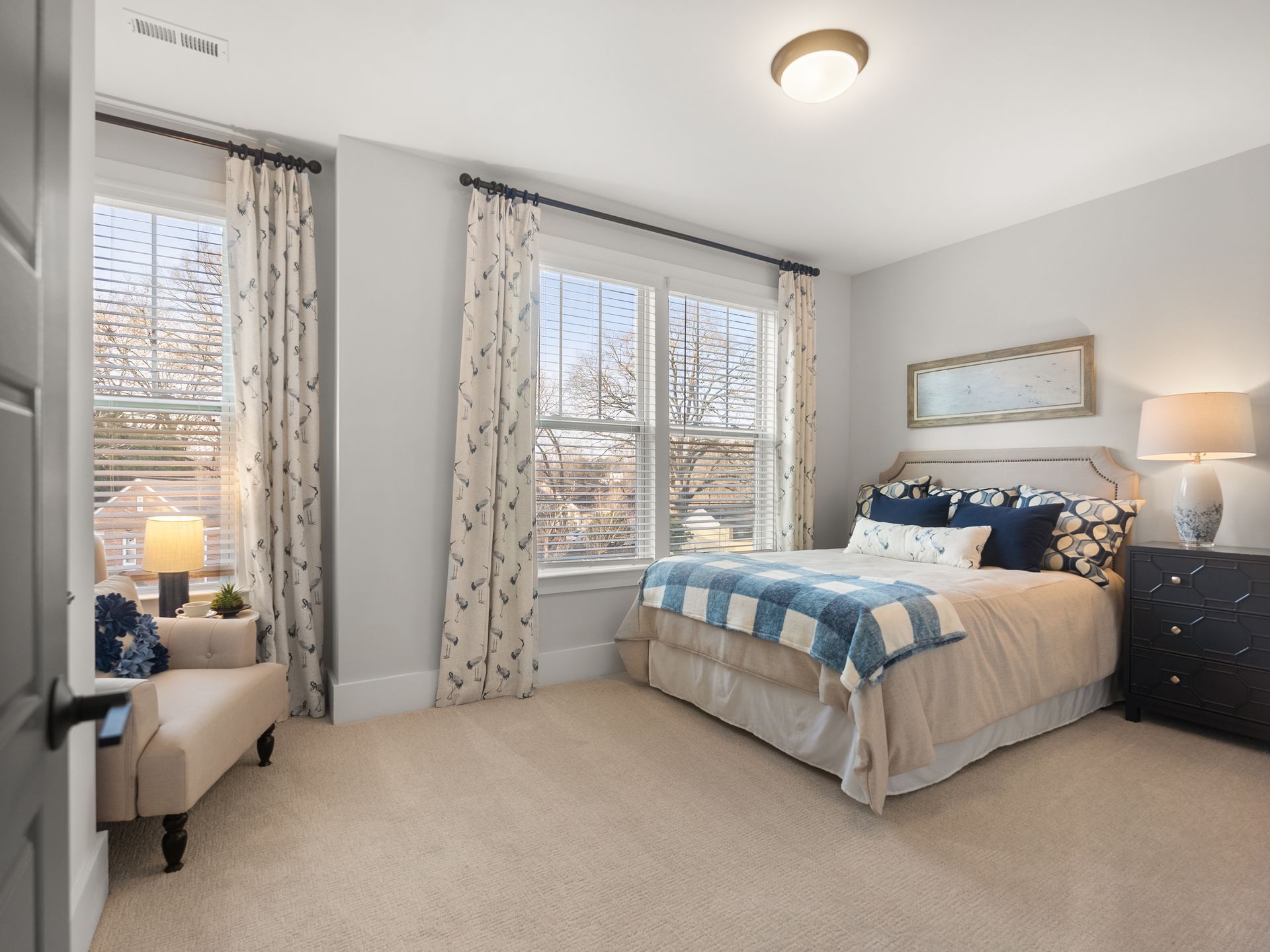 A bedroom with a large bed and a chair