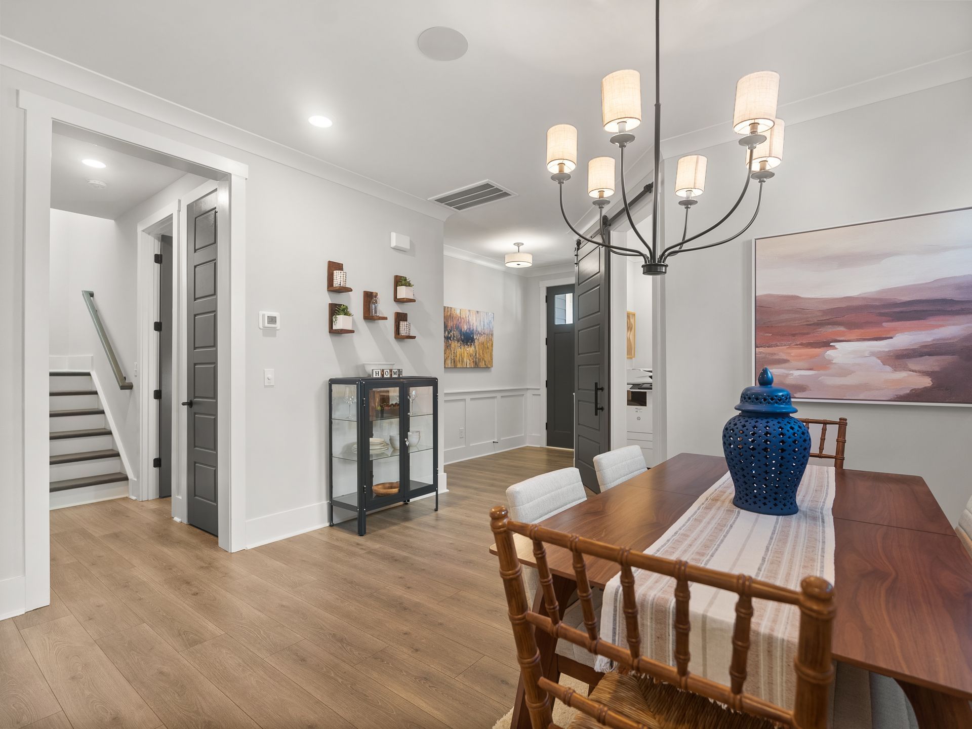 A dining room with a table and chairs and a chandelier.