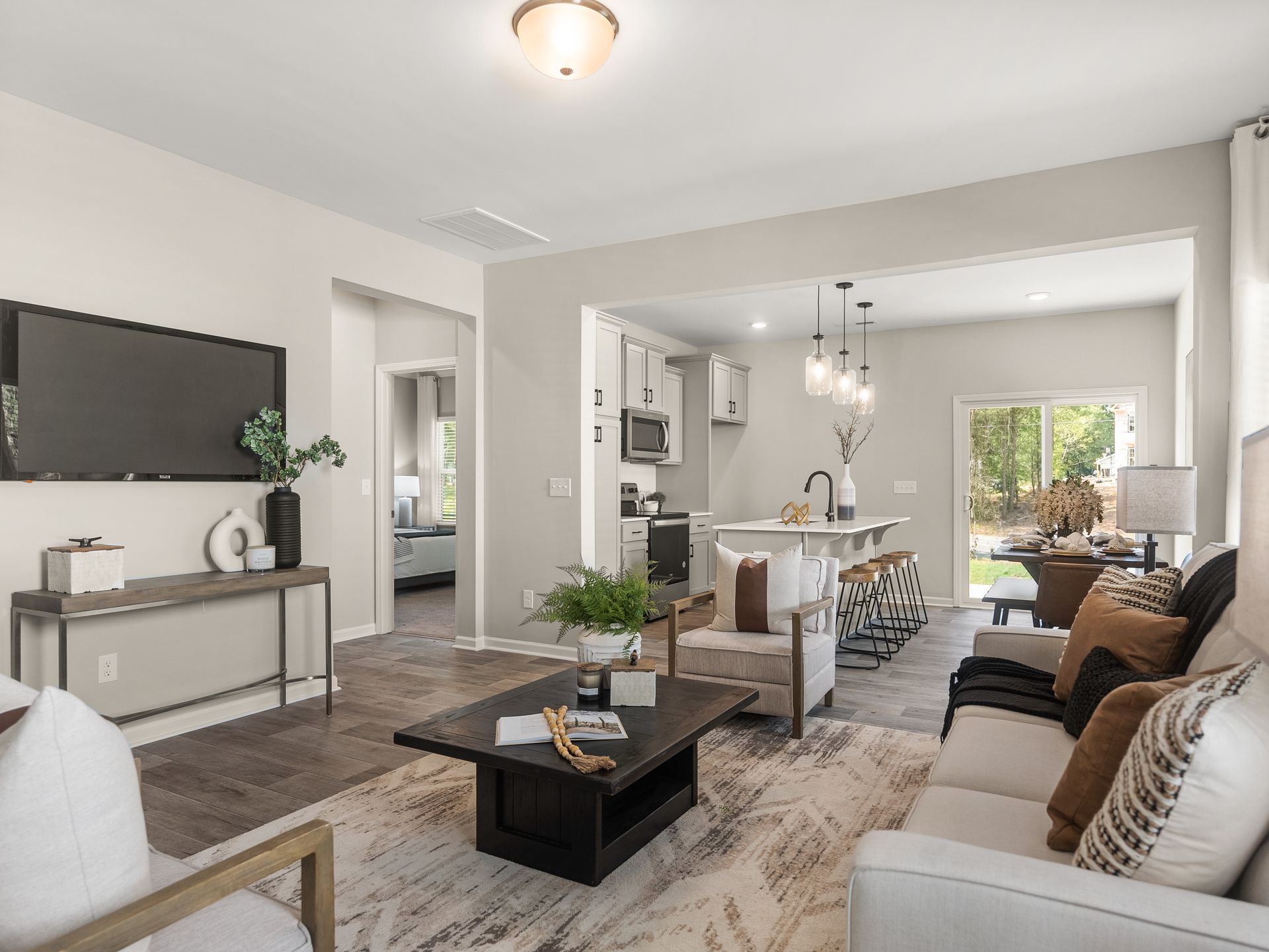 A living room with a couch , chairs , coffee table and television.