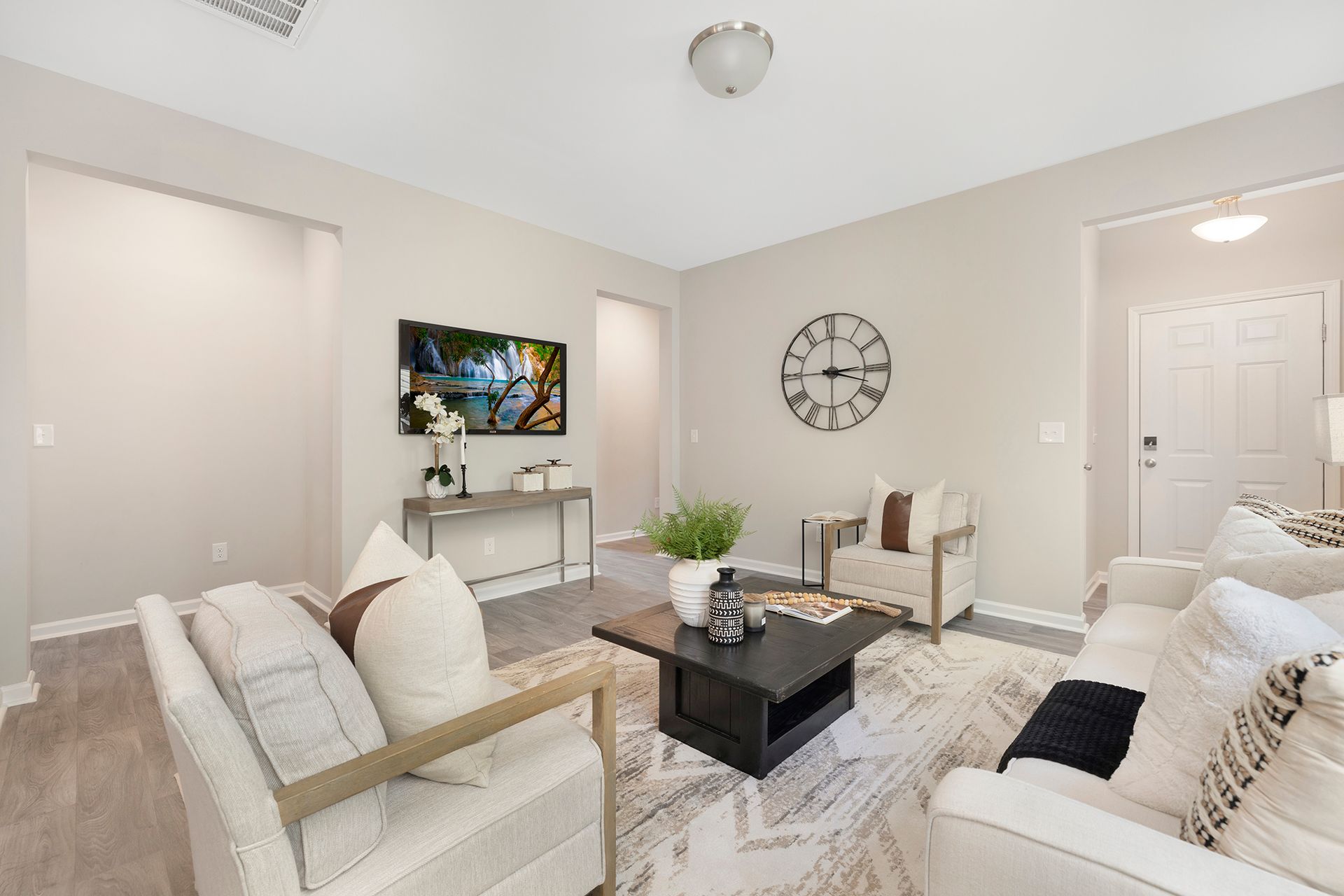 A living room filled with furniture and a clock on the wall.