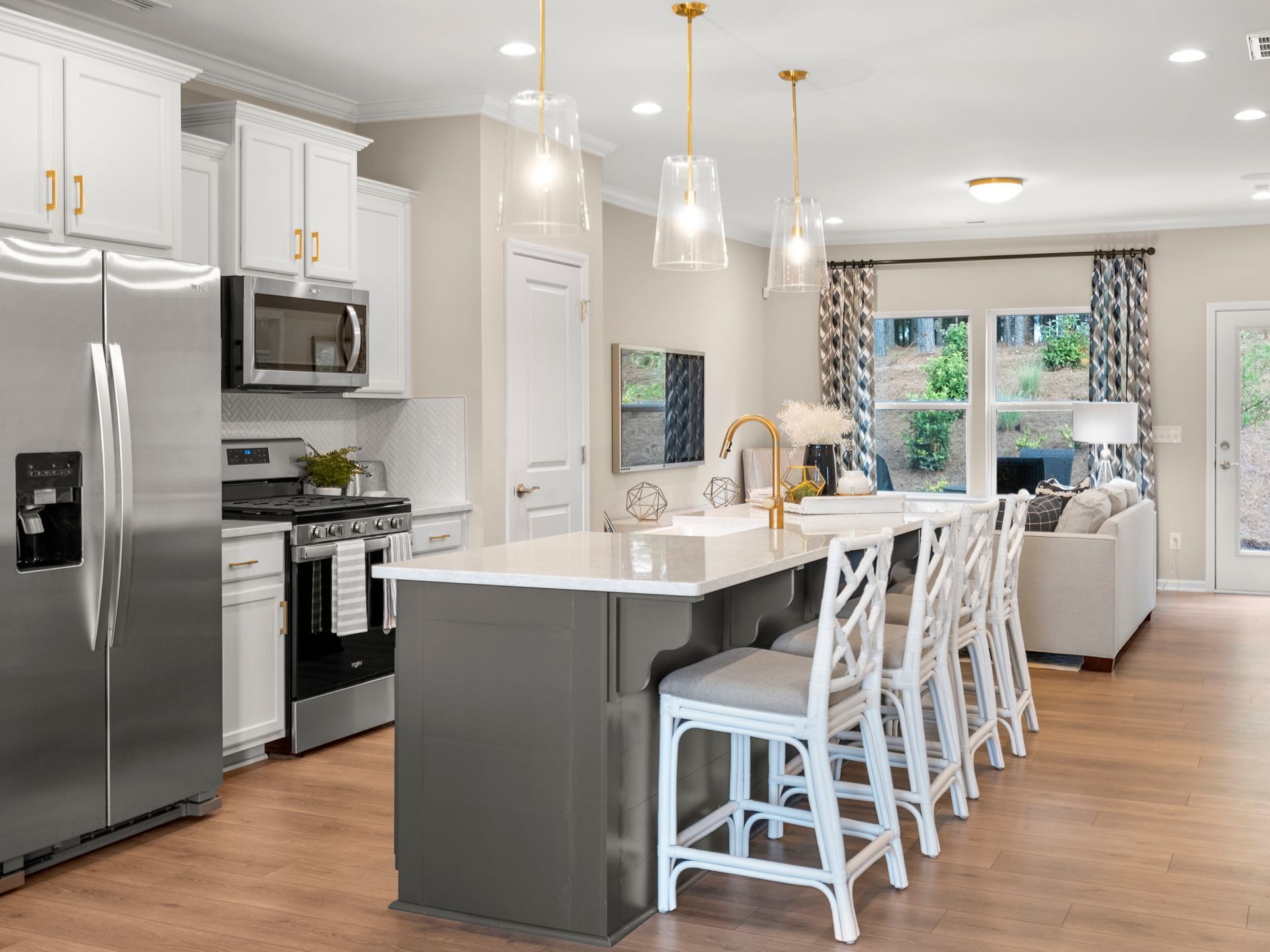 A kitchen in a model home with stainless steel appliances and a large island.