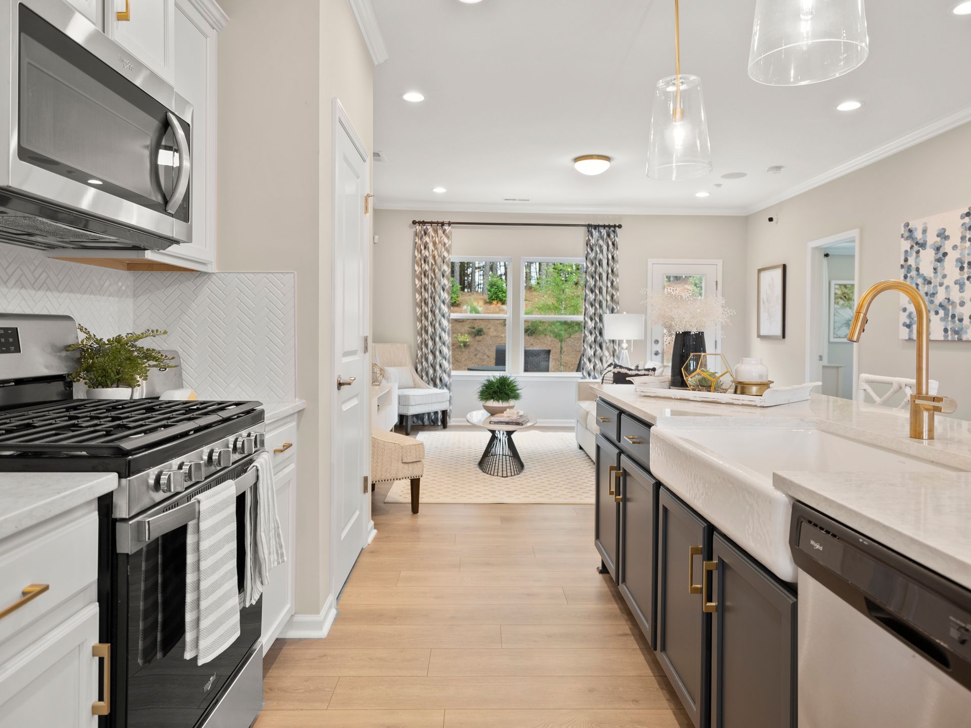 A kitchen with a stove , microwave , sink and dishwasher.