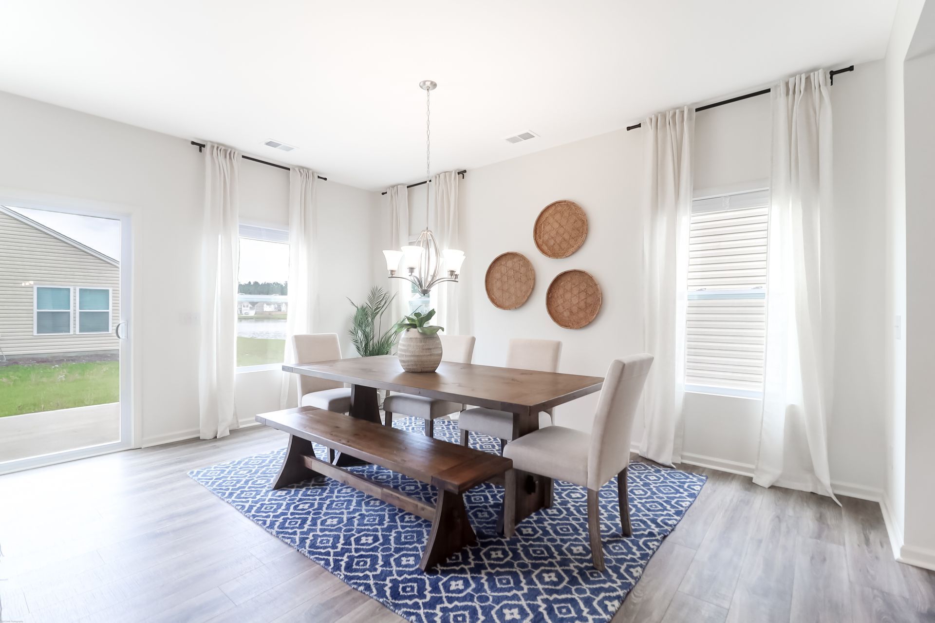 A dining room with a table and chairs and a rug.