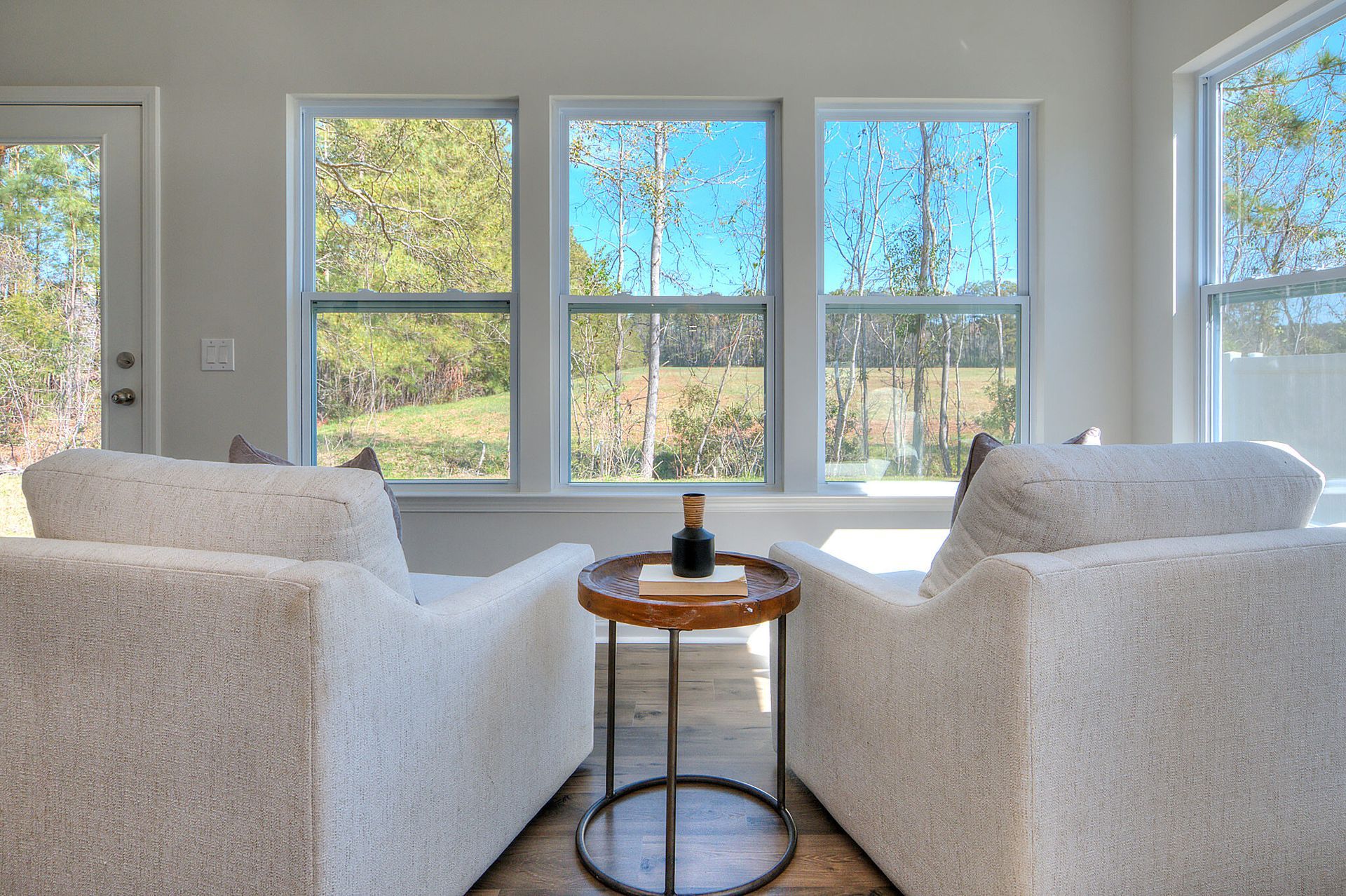 There are two chairs and a table in the living room.