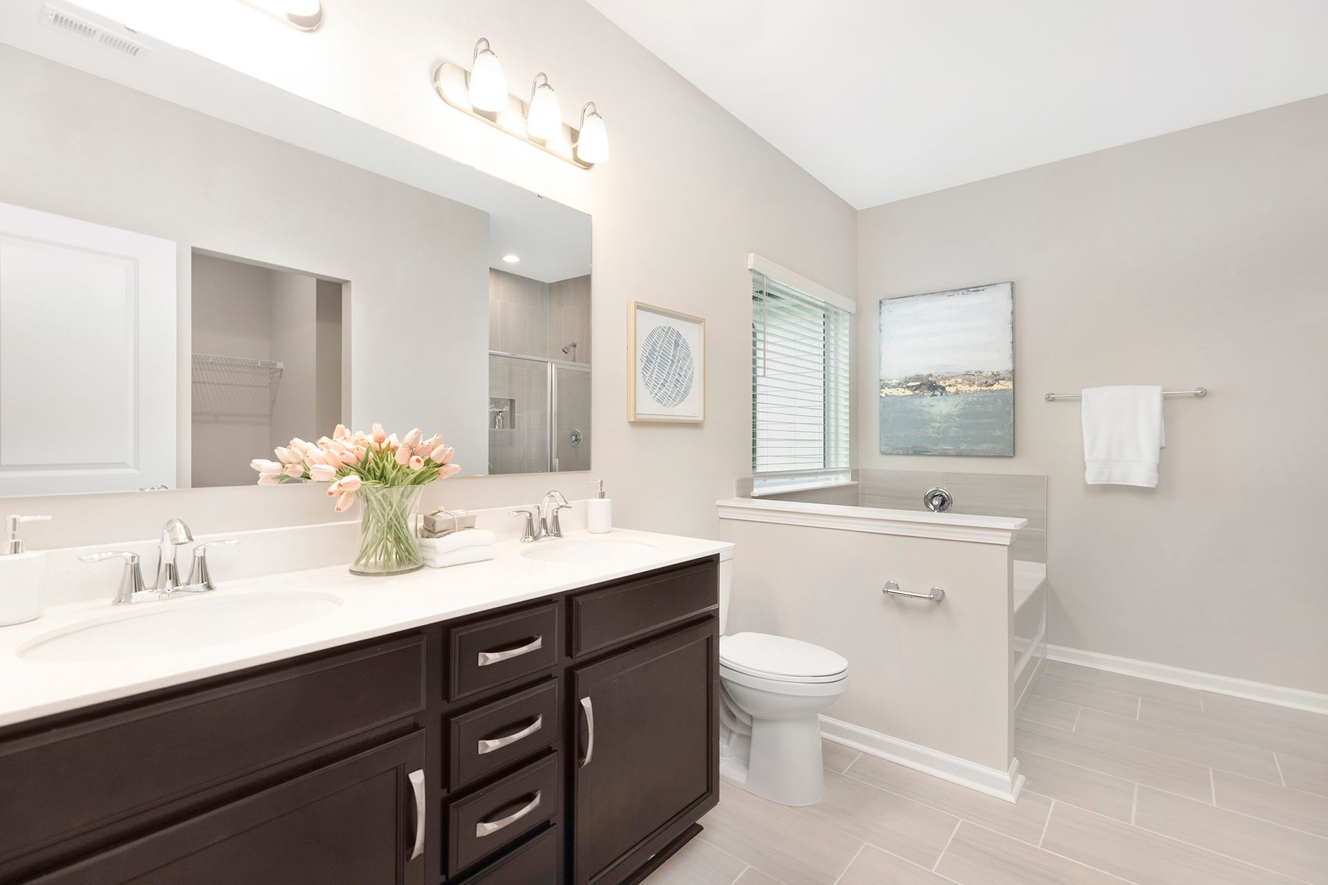 A bathroom with two sinks , a toilet , and a large mirror.