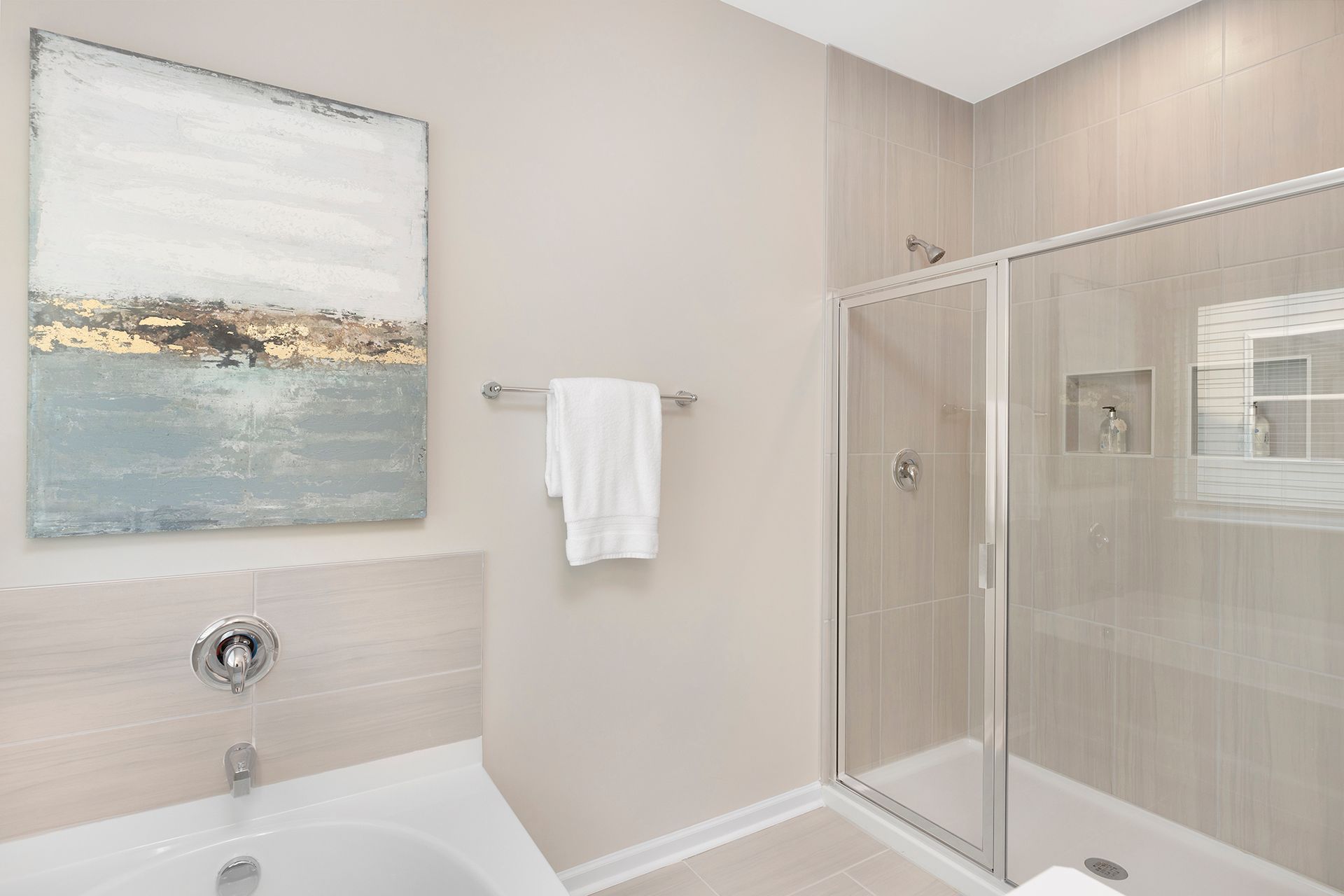 A bathroom with a tub , shower and a painting on the wall.