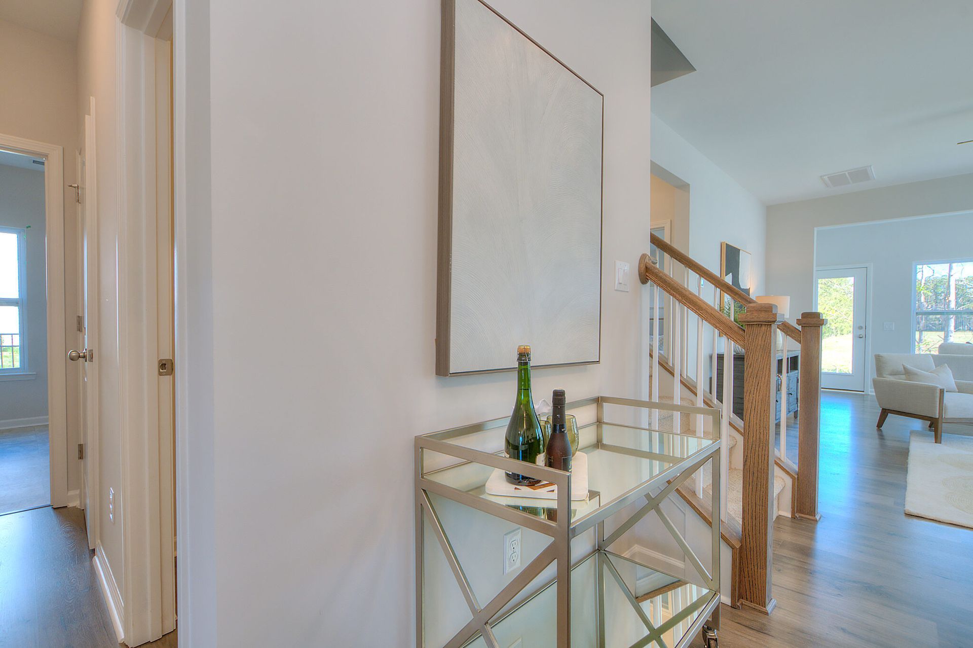 A hallway in a house with a bar cart and a mirror.