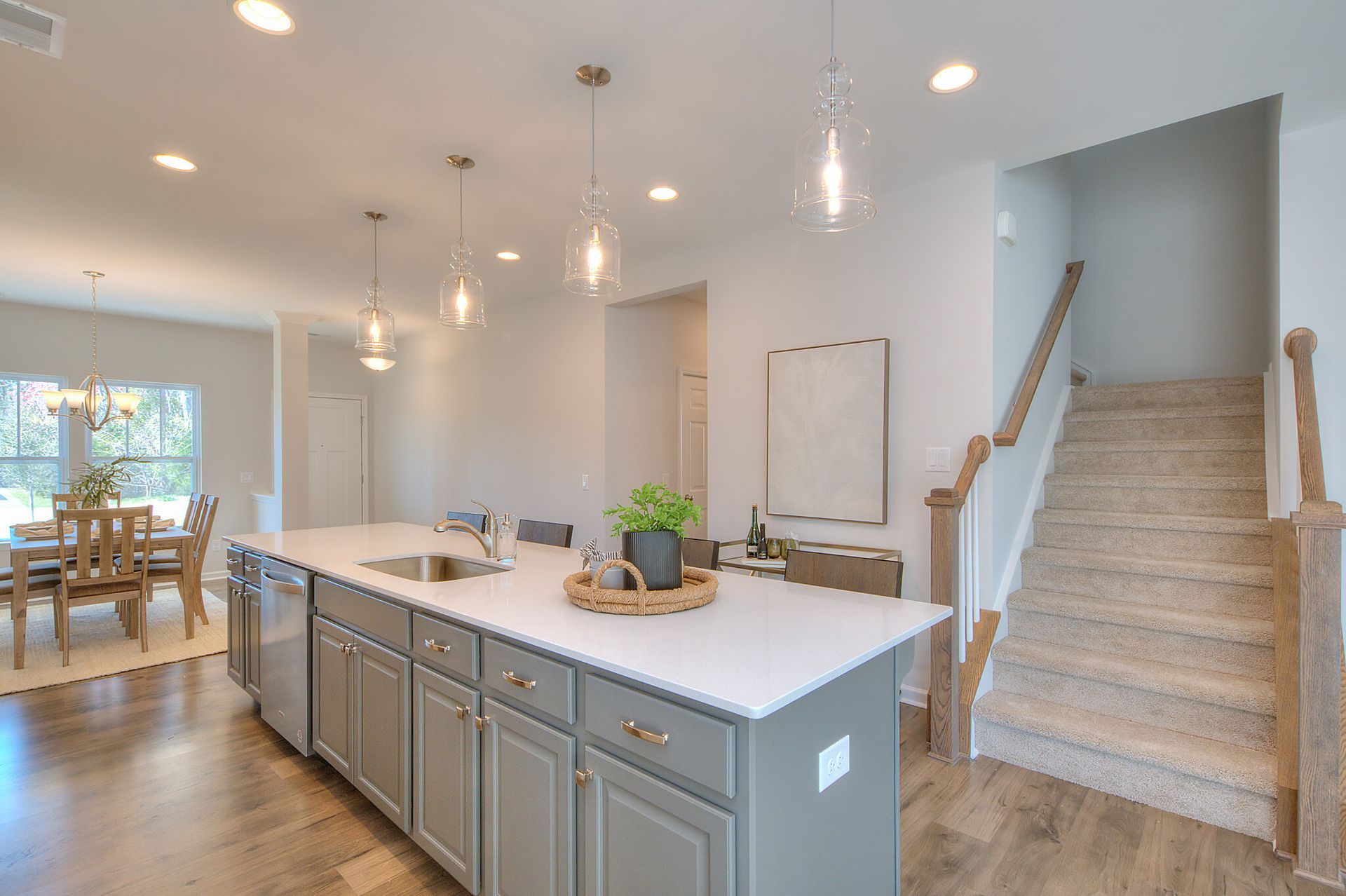 A kitchen with a large island and stairs leading to the second floor.