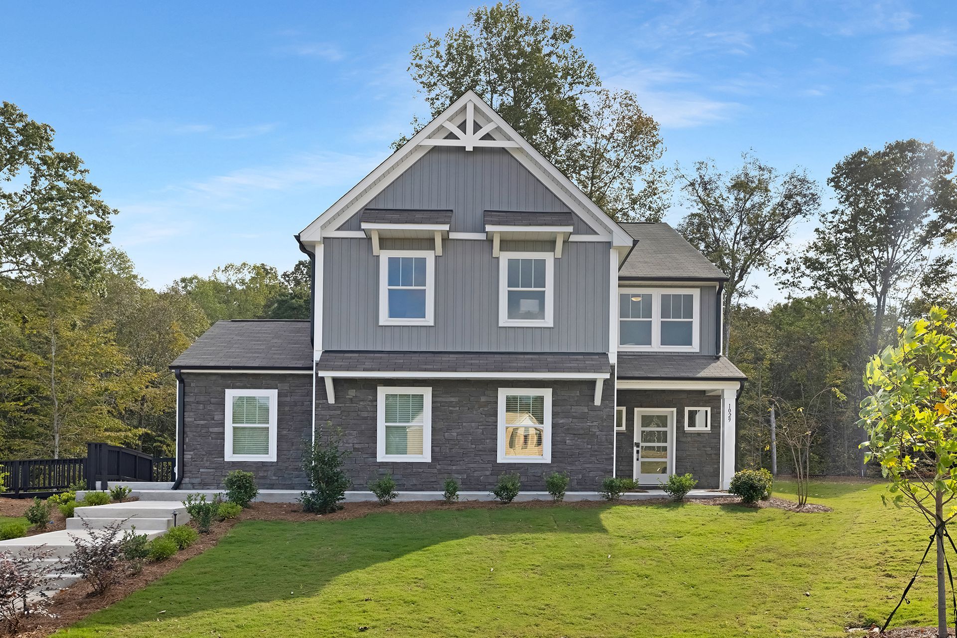 A rendering of a house with a garage and a lot of windows.