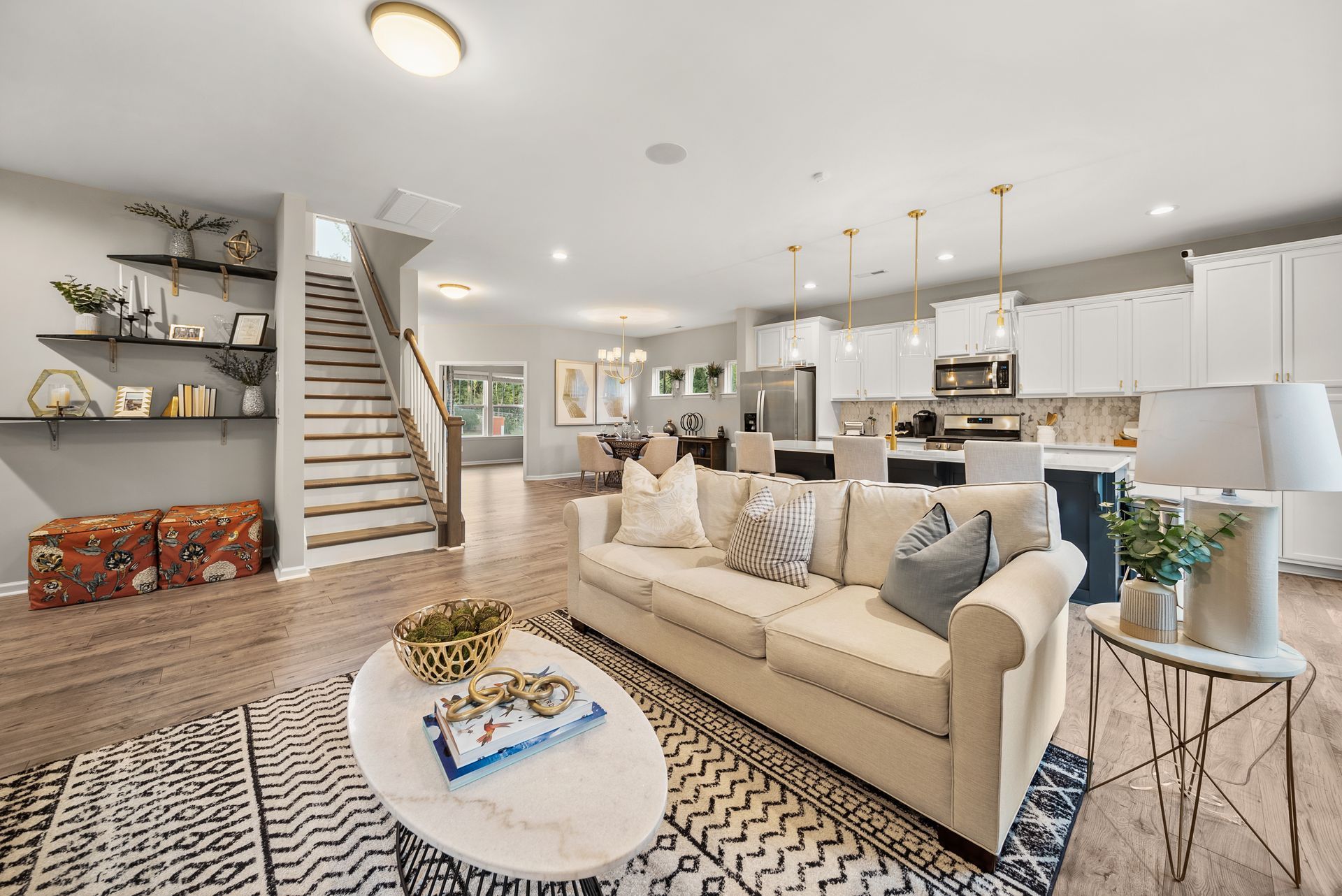 A living room with a couch , coffee table , and stairs.