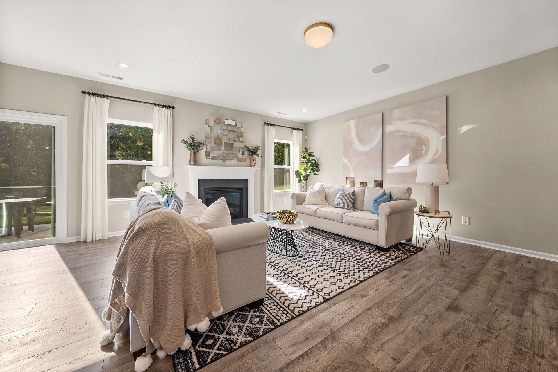 A living room with a couch , chair , fireplace and rug.