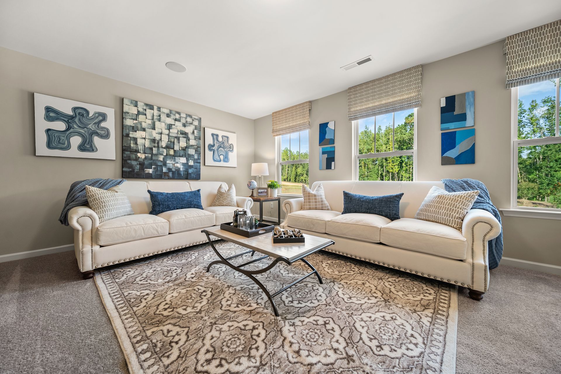 A living room with two couches , a coffee table , and a rug.