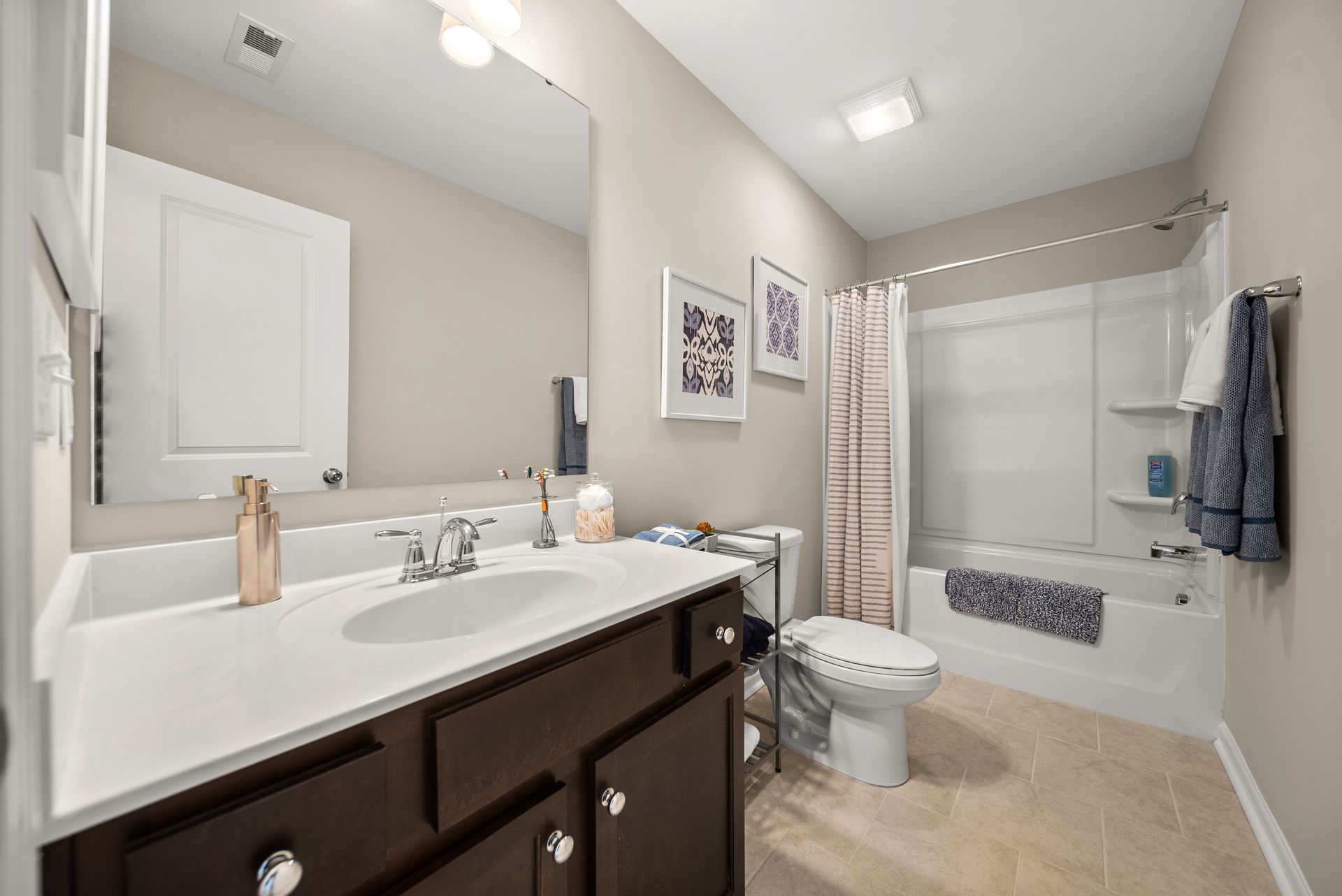 A bathroom with a sink , toilet , tub and mirror.