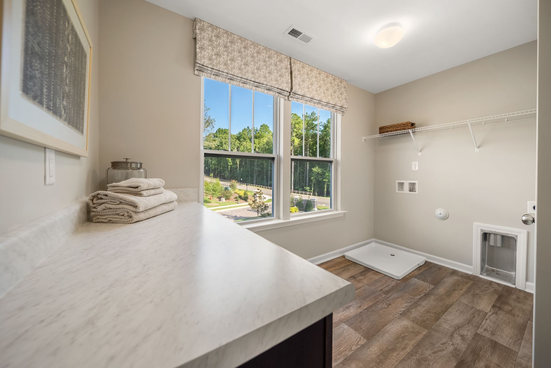 A laundry room with a large window and a sink.