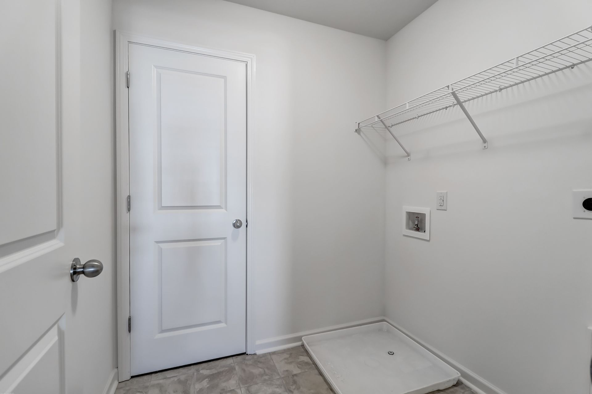 A laundry room with a washer and dryer and a door.