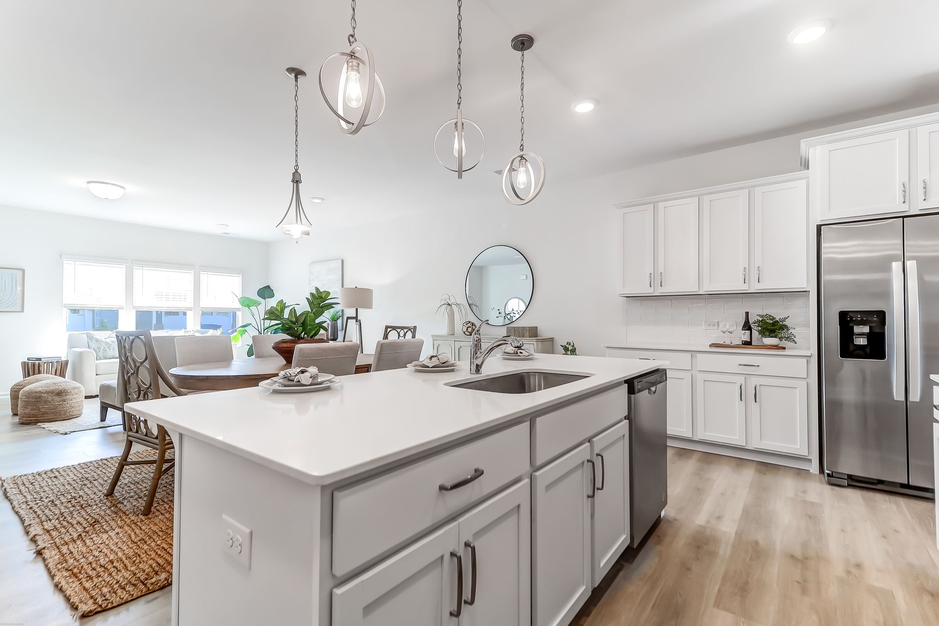 A kitchen with white cabinets , stainless steel appliances , and a large island.