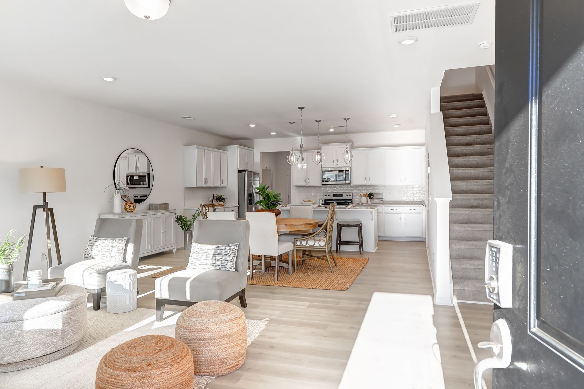 A living room with a staircase leading to the kitchen and dining room.