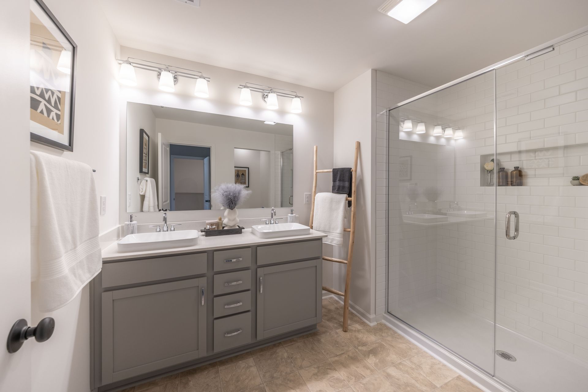 A bathroom with two sinks and a walk in shower.