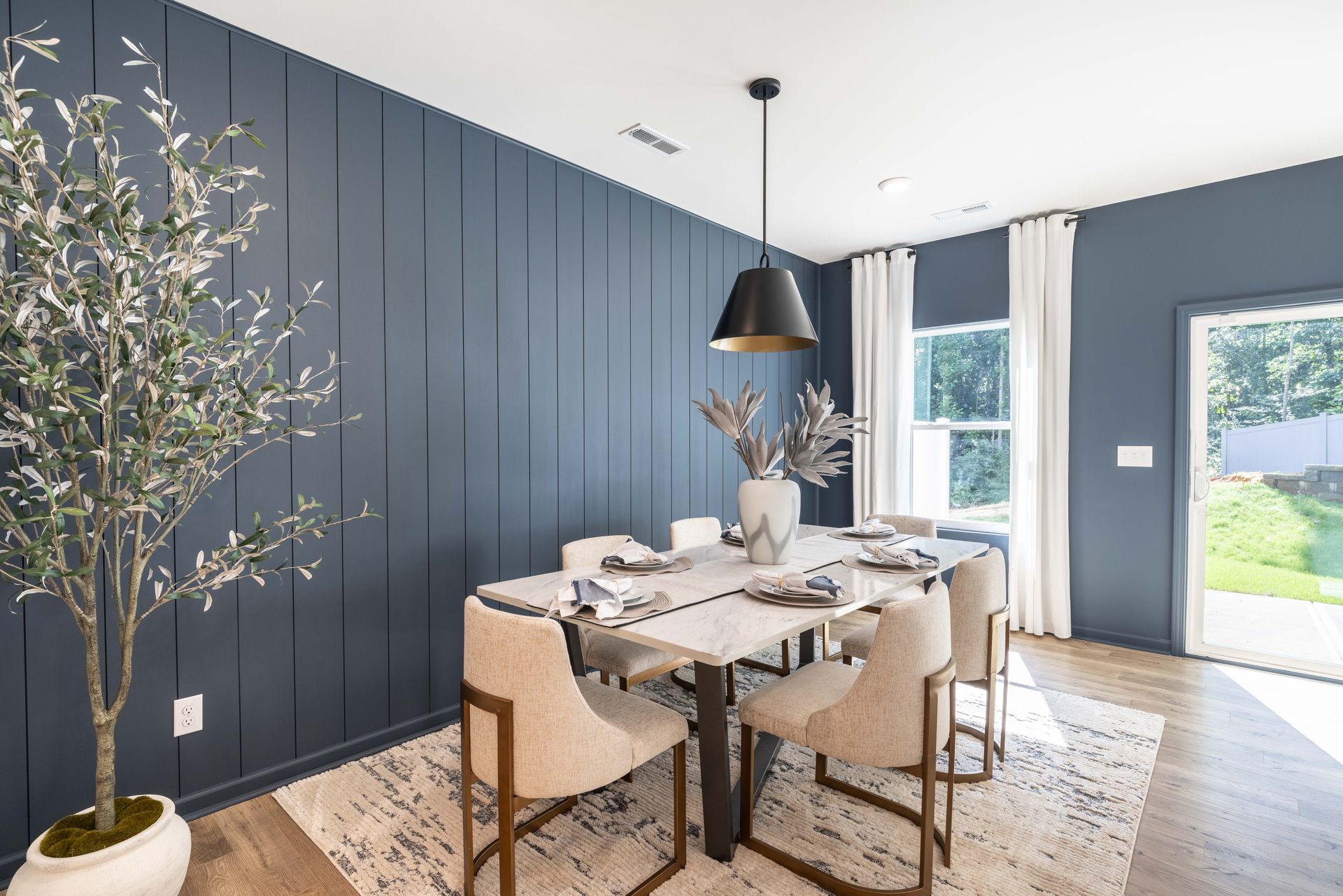 A dining room with a table and chairs and blue walls.