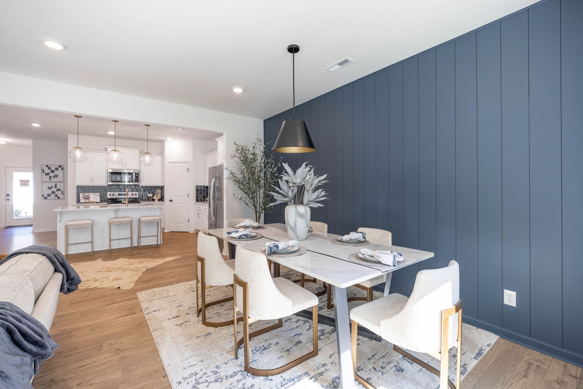 A dining room with a table and chairs and a blue wall.