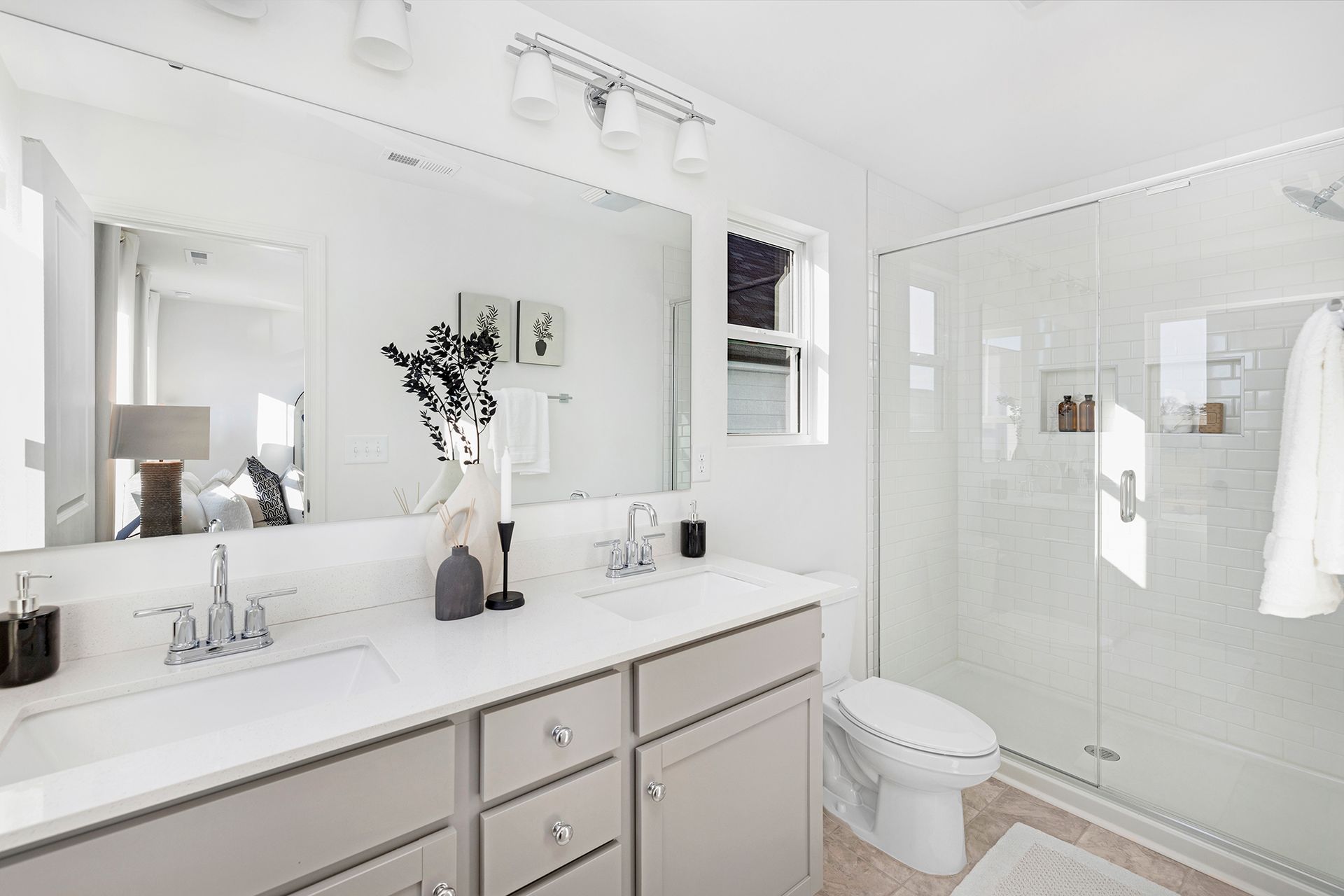 A bathroom with a toilet , sink , mirror and walk in shower.