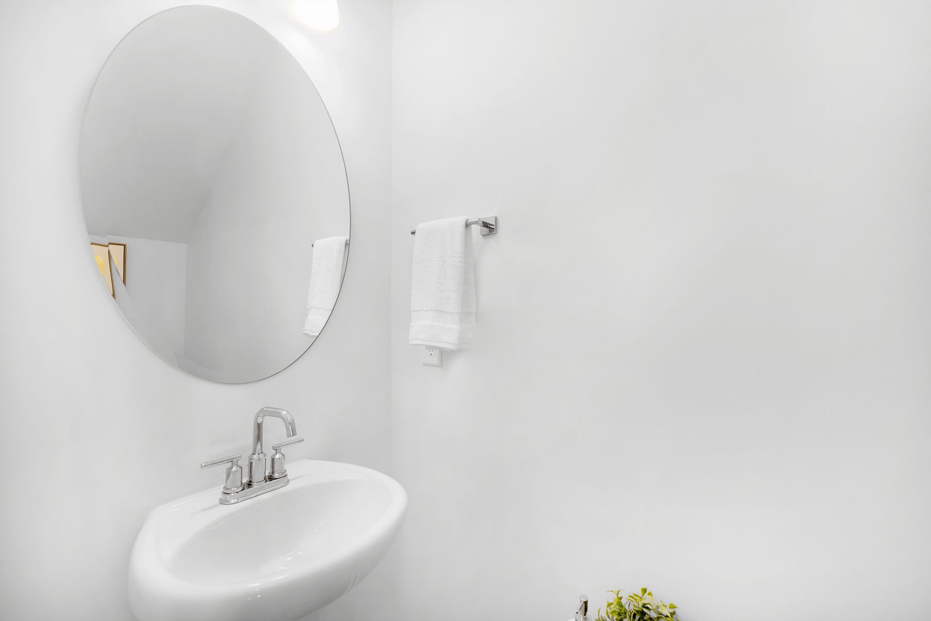 A bathroom with a sink , mirror and towel rack.