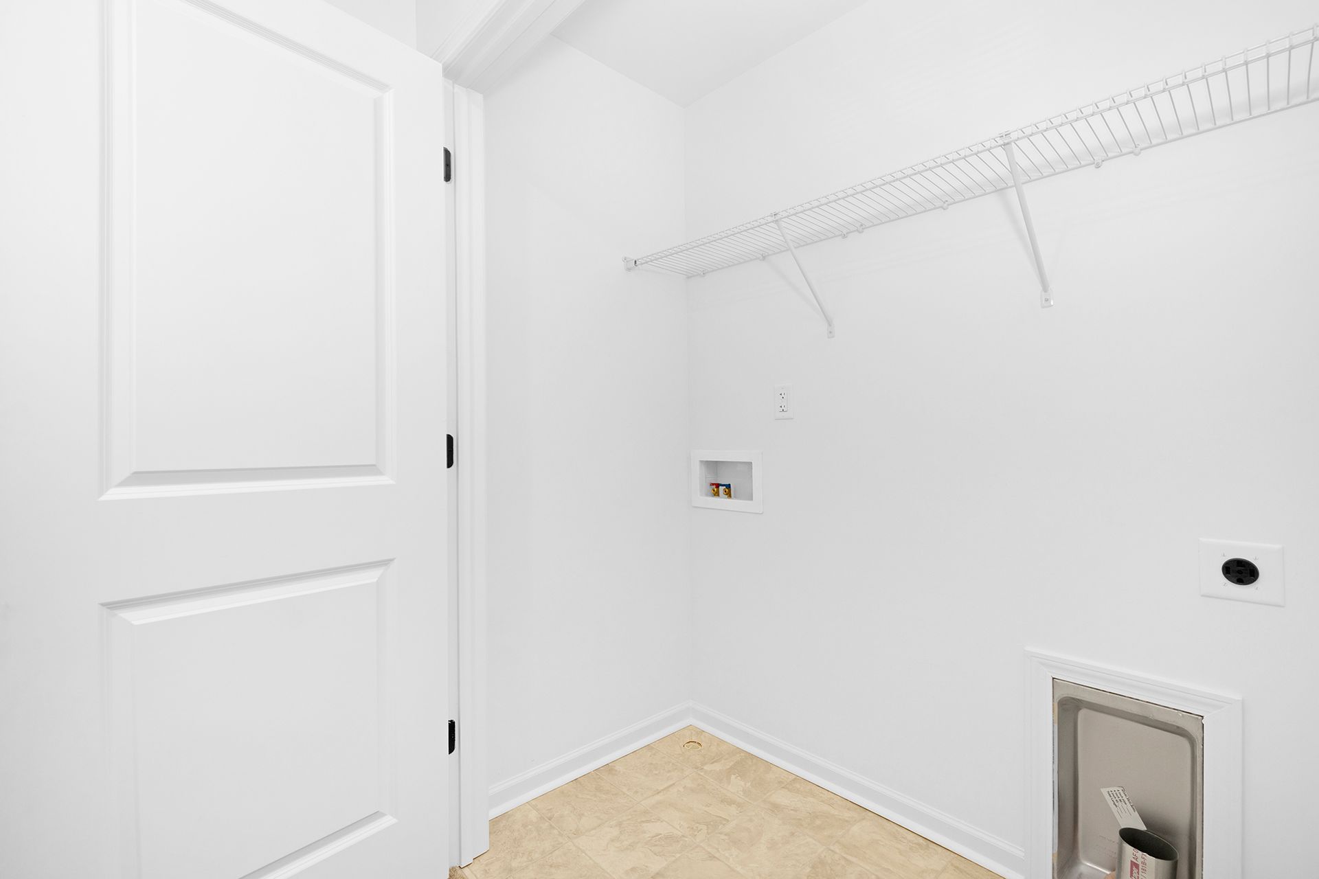 An empty laundry room with a washer and dryer.