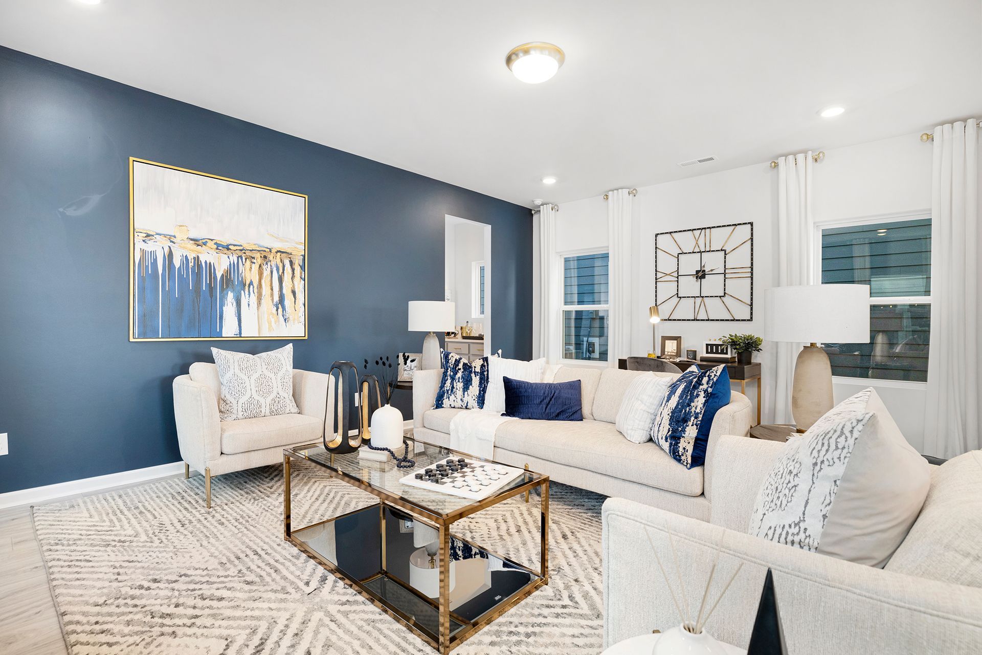 A living room with blue walls and white furniture