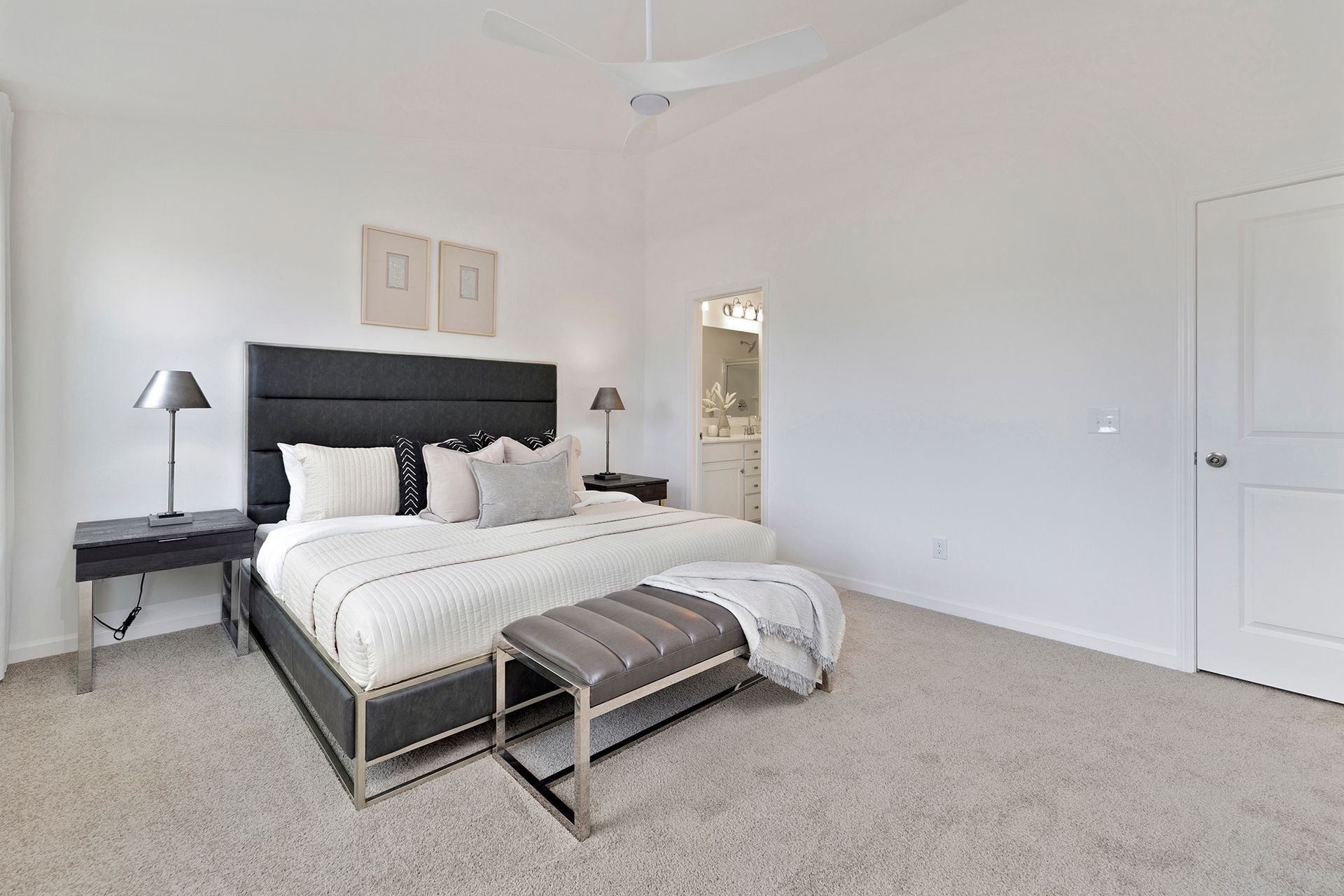 A bedroom with a king size bed and a bench.