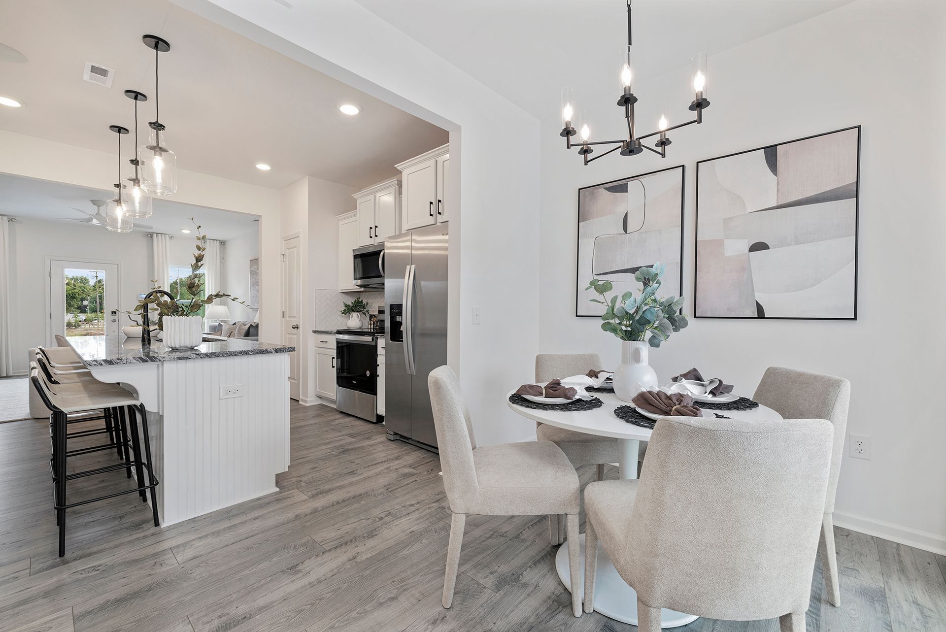 A kitchen and dining room in a house with a table and chairs.