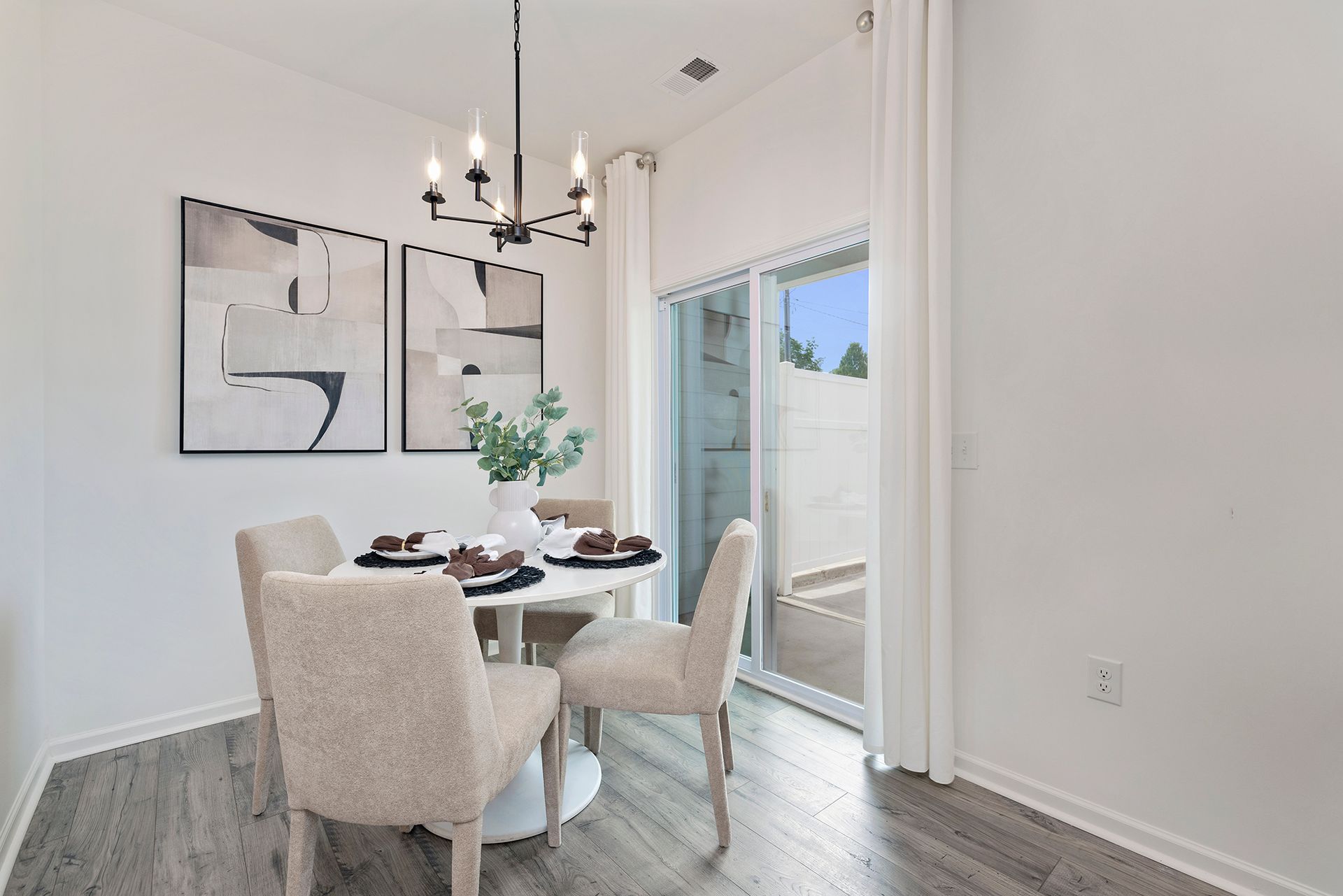 A dining room with a table and chairs and a chandelier.