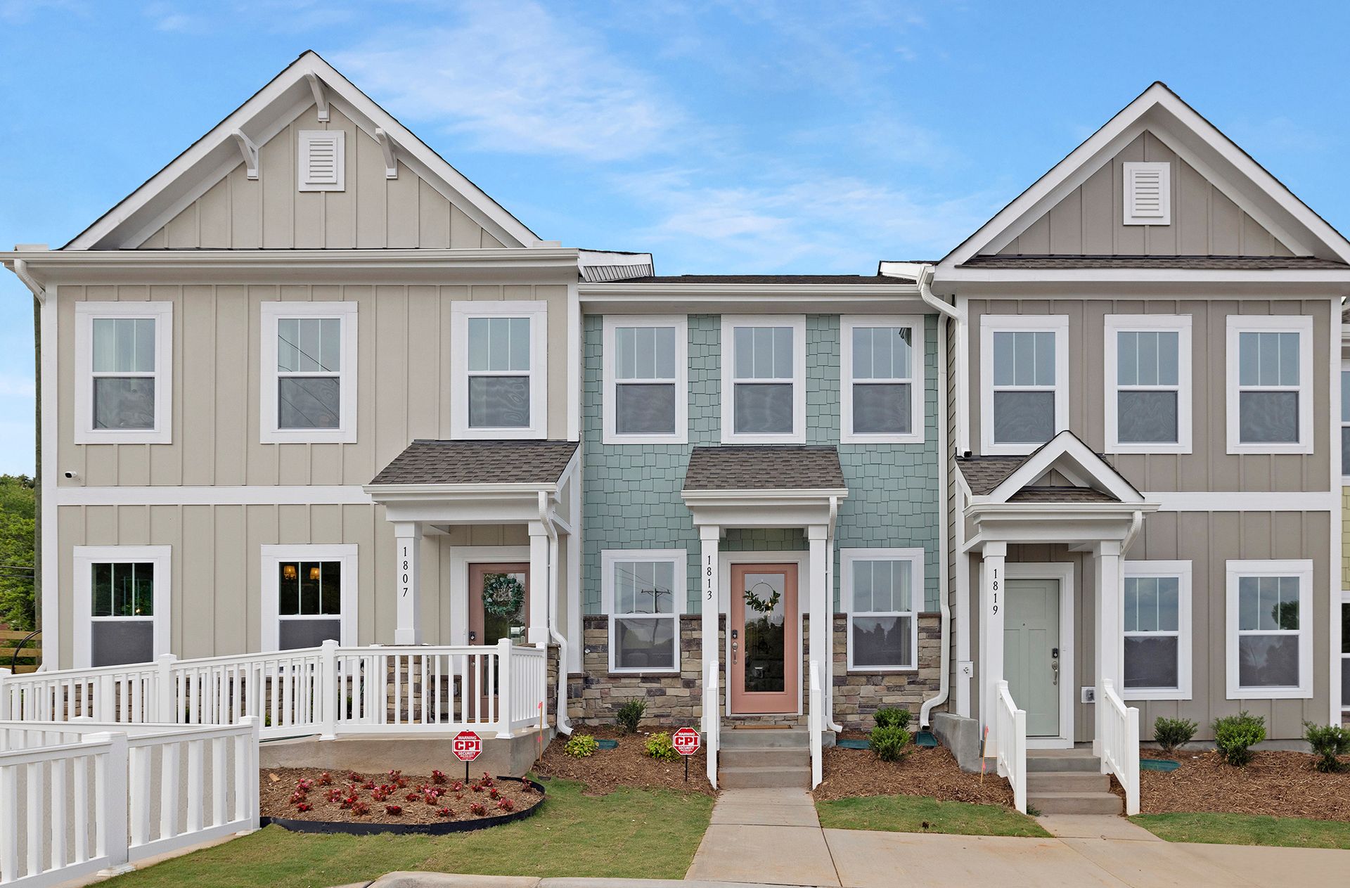 A row of houses with a white fence in front of them.