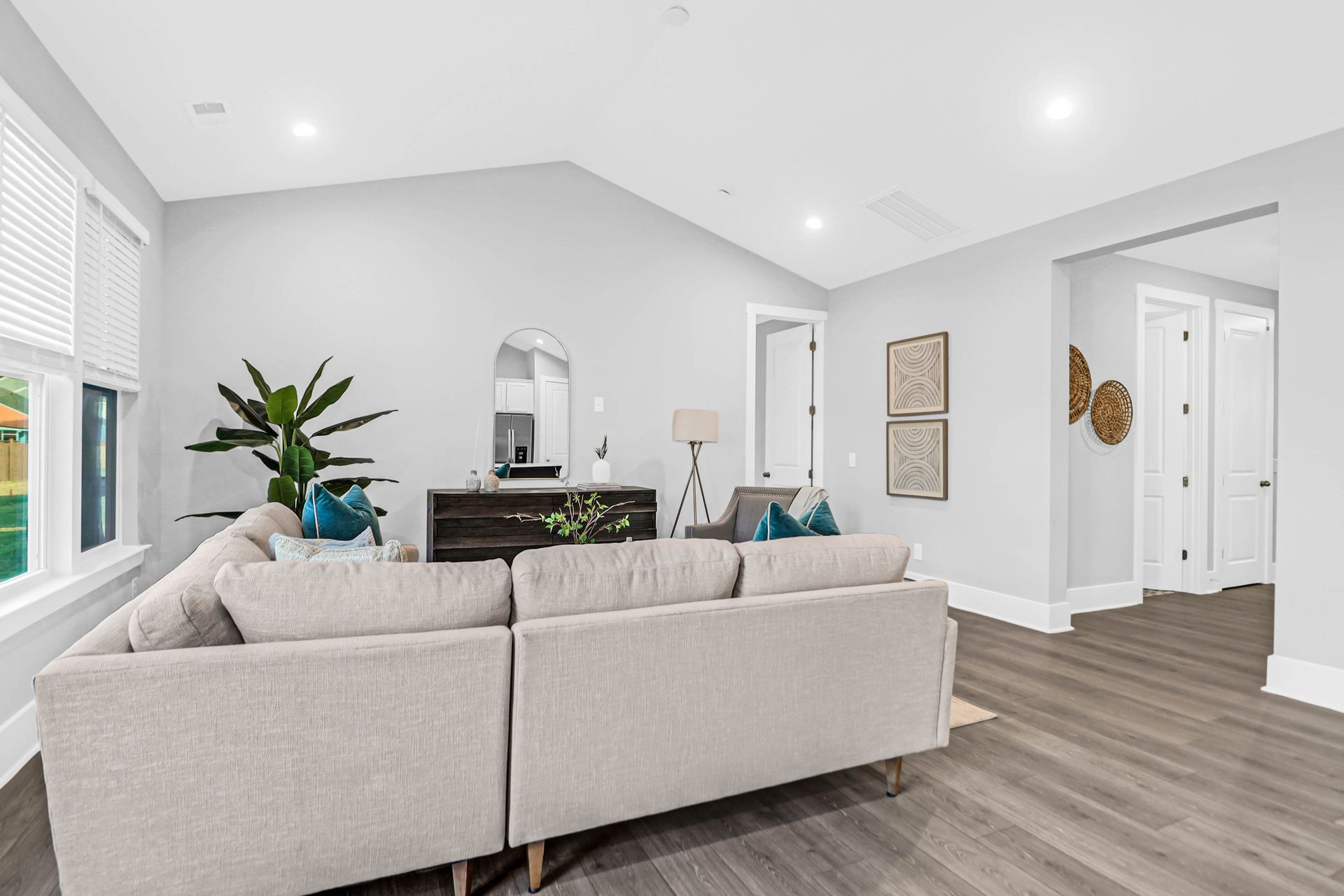 A living room with a couch , chairs , and a vaulted ceiling.