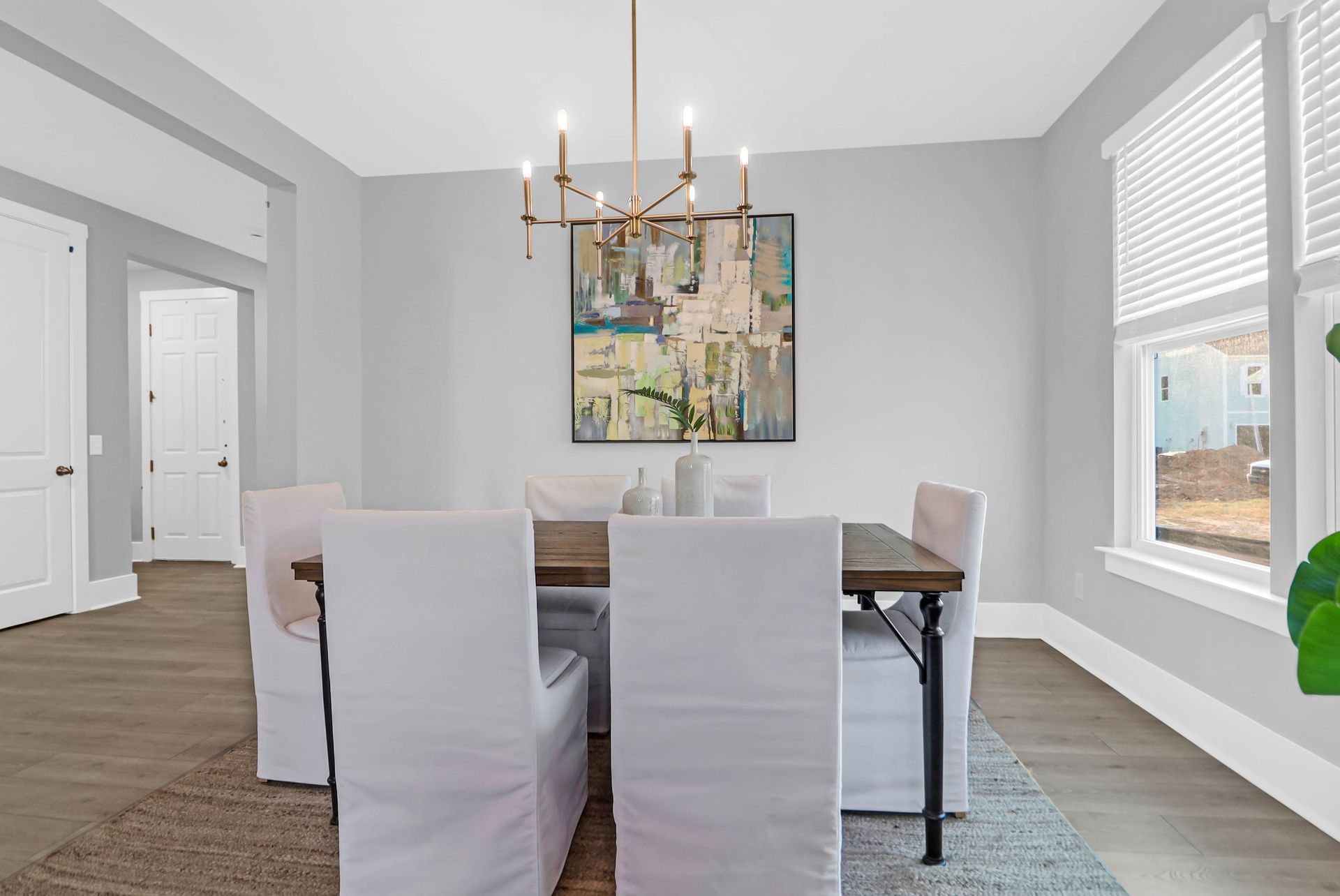 A dining room with a table and chairs and a chandelier.
