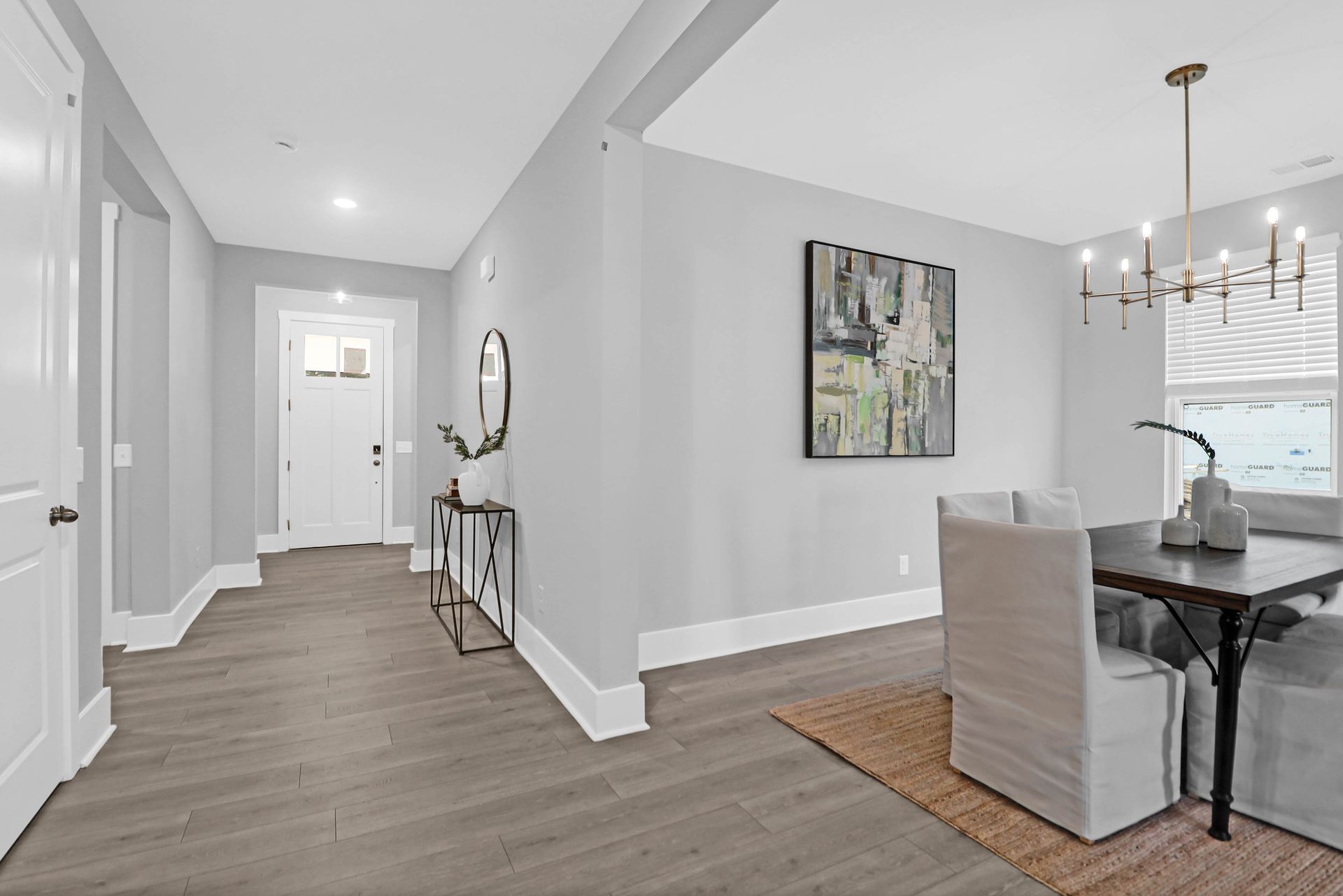 A hallway leading to a dining room with a table and chairs.