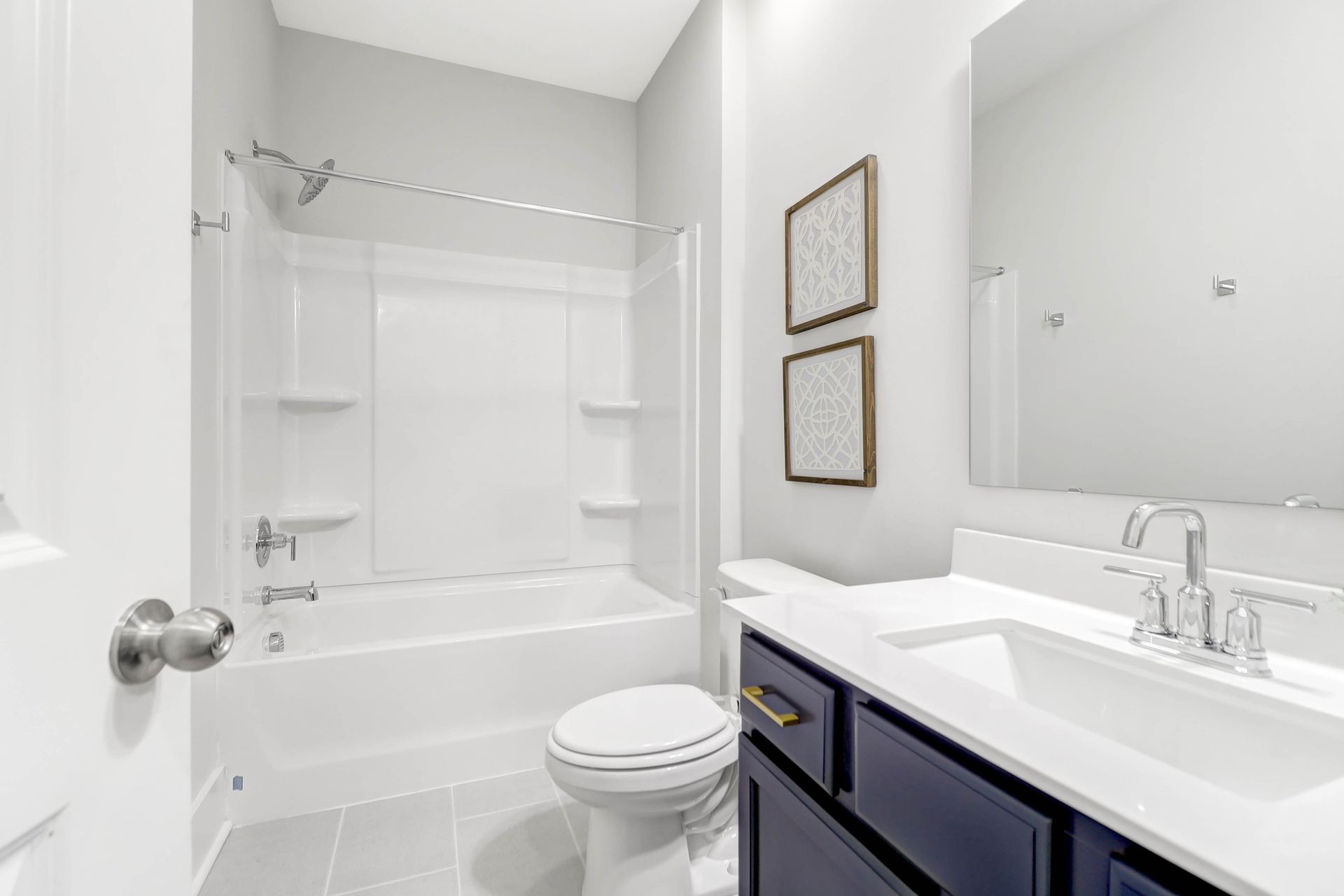 A bathroom with a toilet , sink , bathtub and mirror.