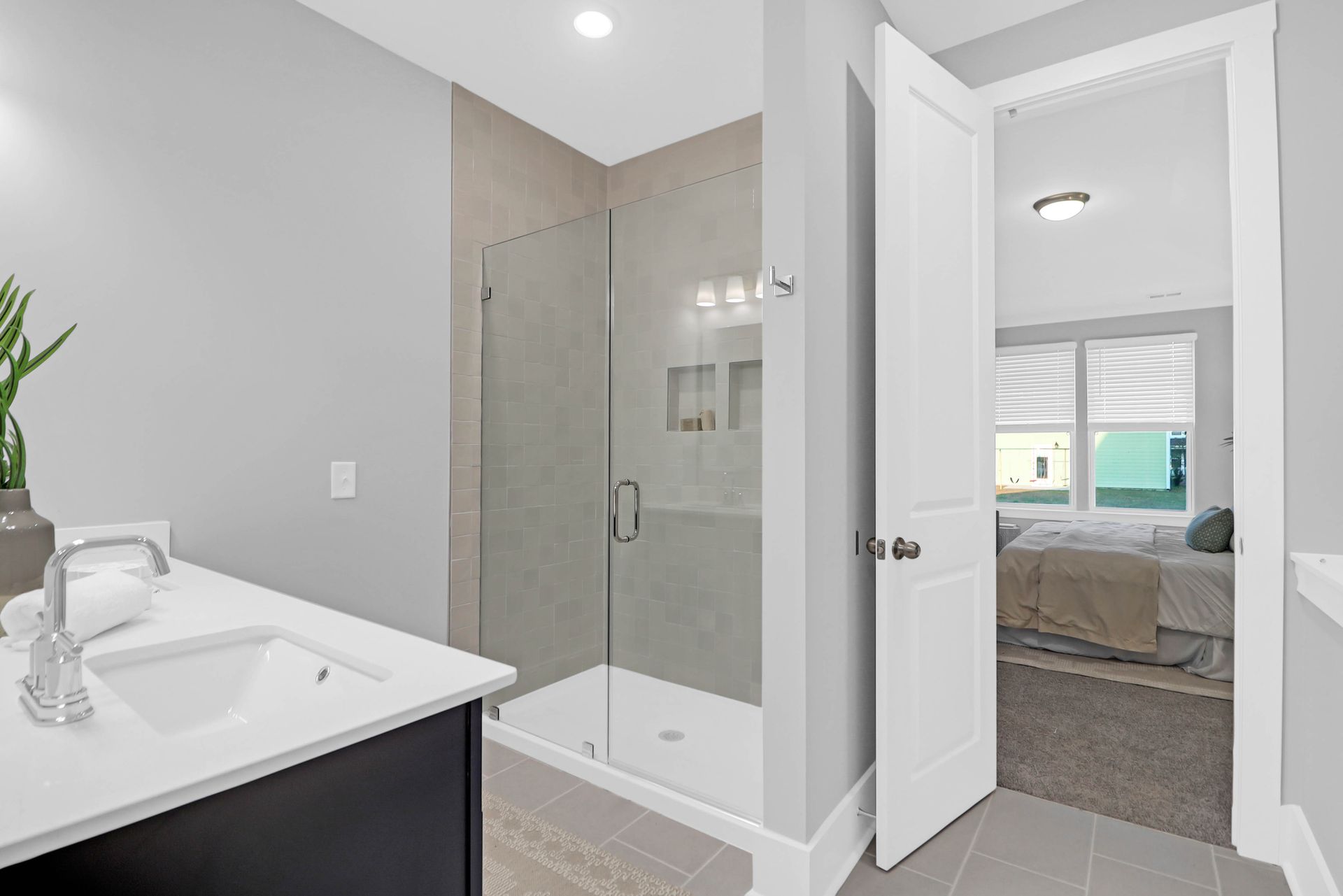 A bathroom with a walk in shower and a sink.