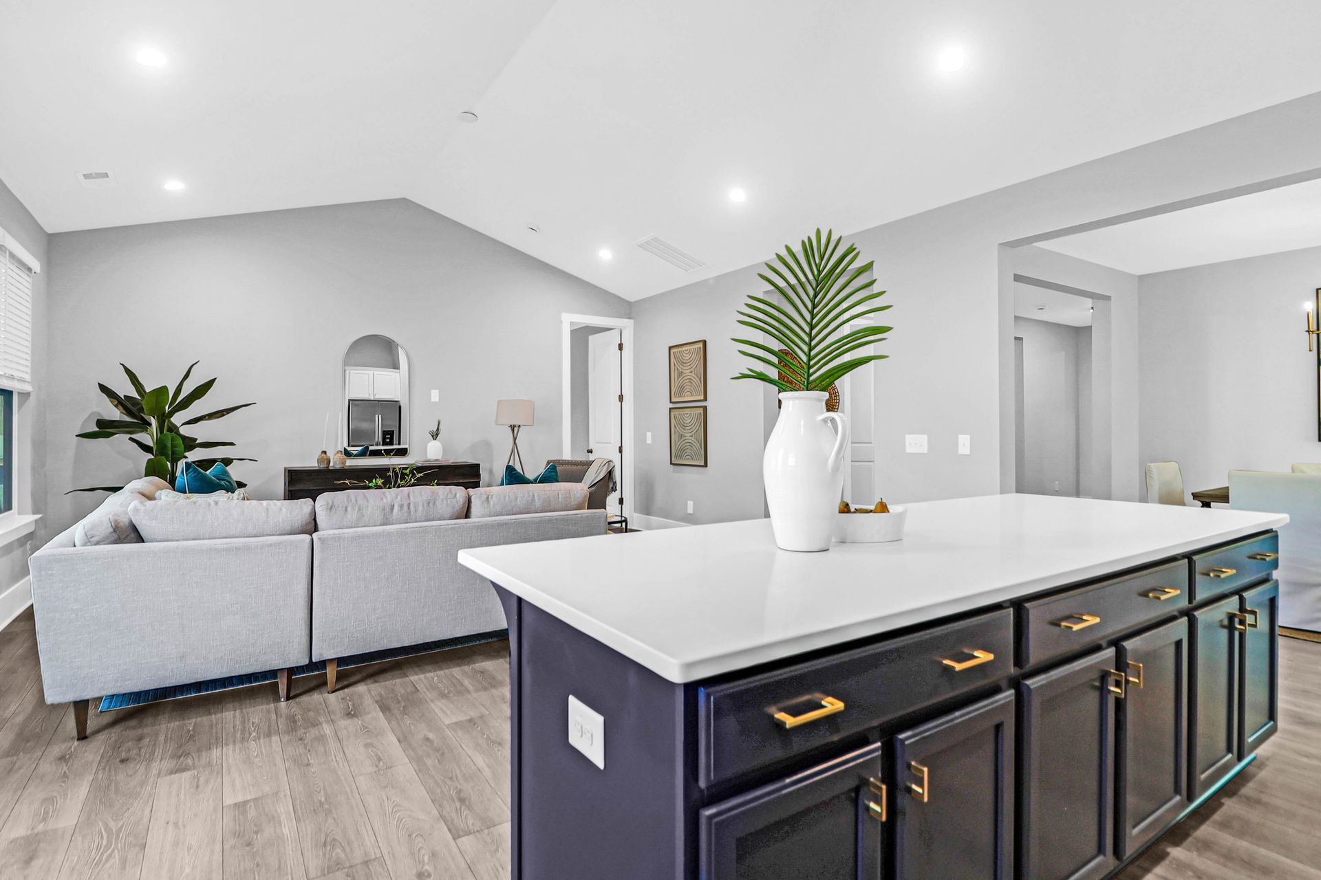 A kitchen with a large island and a couch in the background.