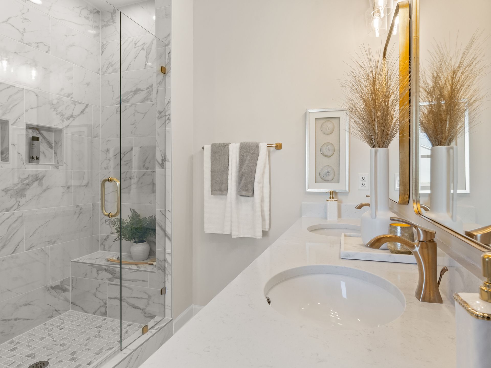 A bathroom with two sinks and a walk in shower.