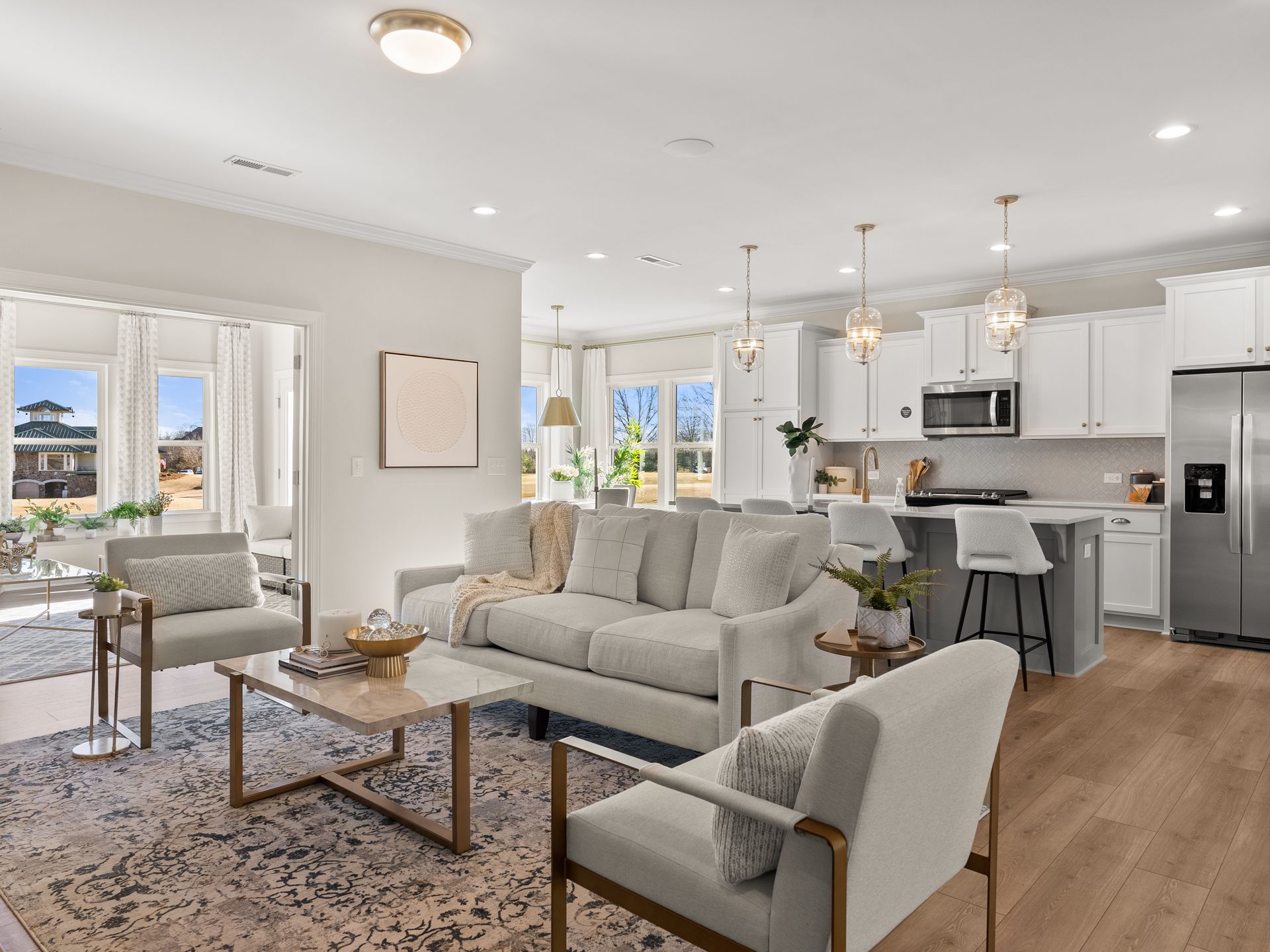 A living room with a couch , chairs , a coffee table and a refrigerator.