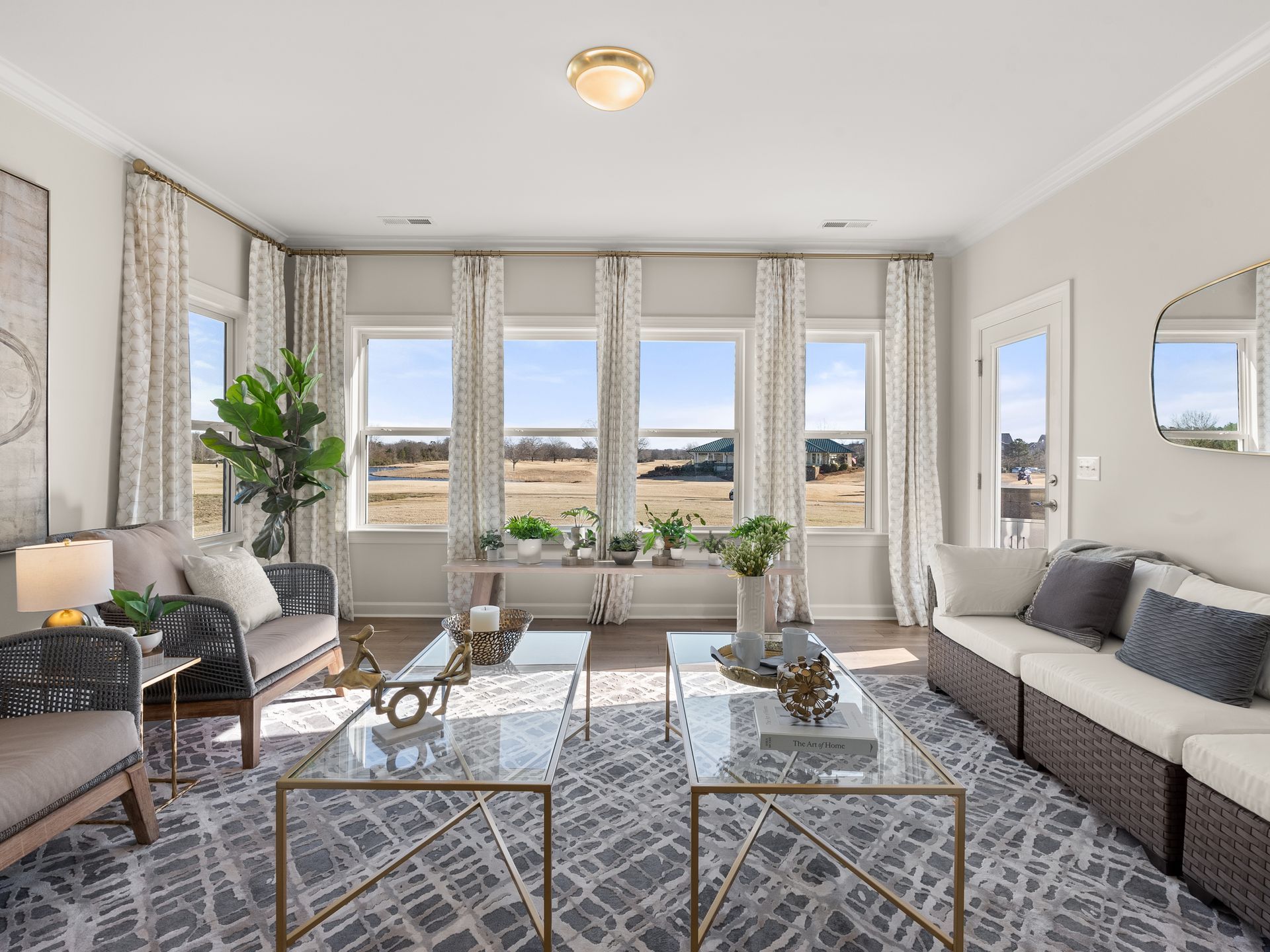A living room with a lot of windows and furniture.
