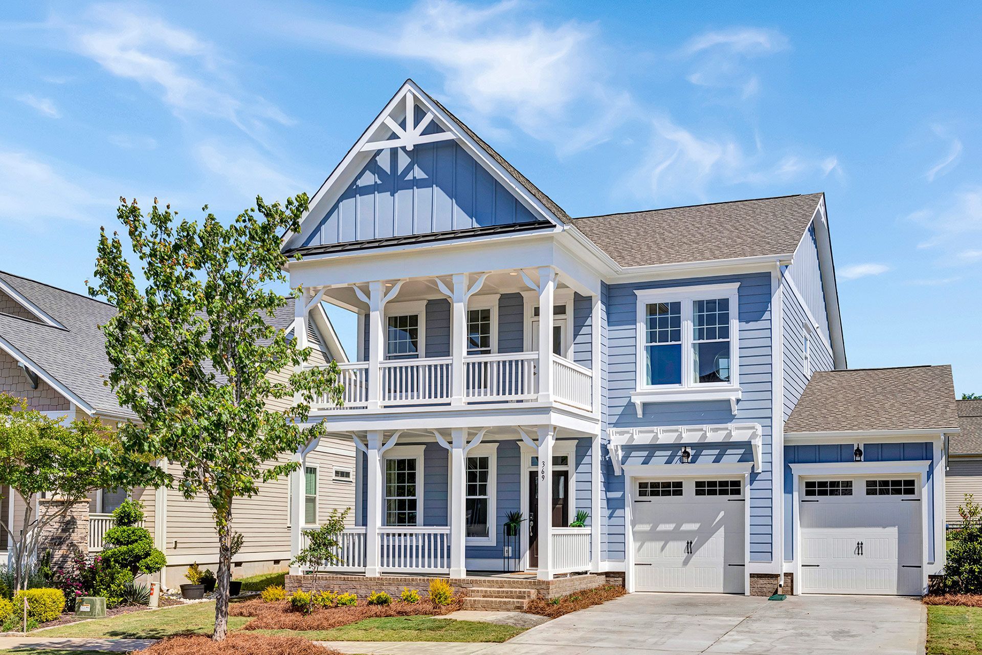 A blue and white house with a porch and a garage.