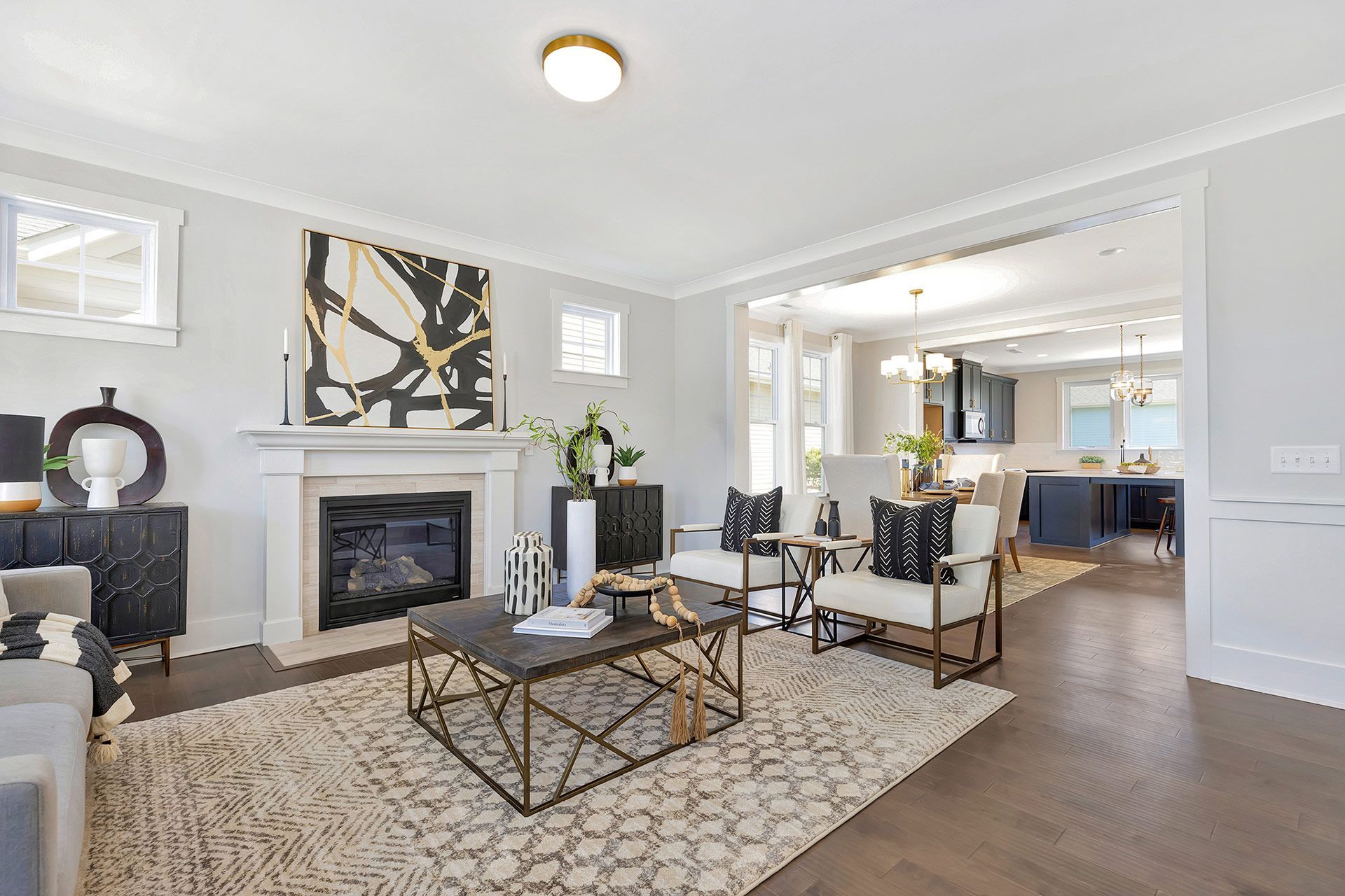 A living room with a fireplace , coffee table , chairs and a rug.