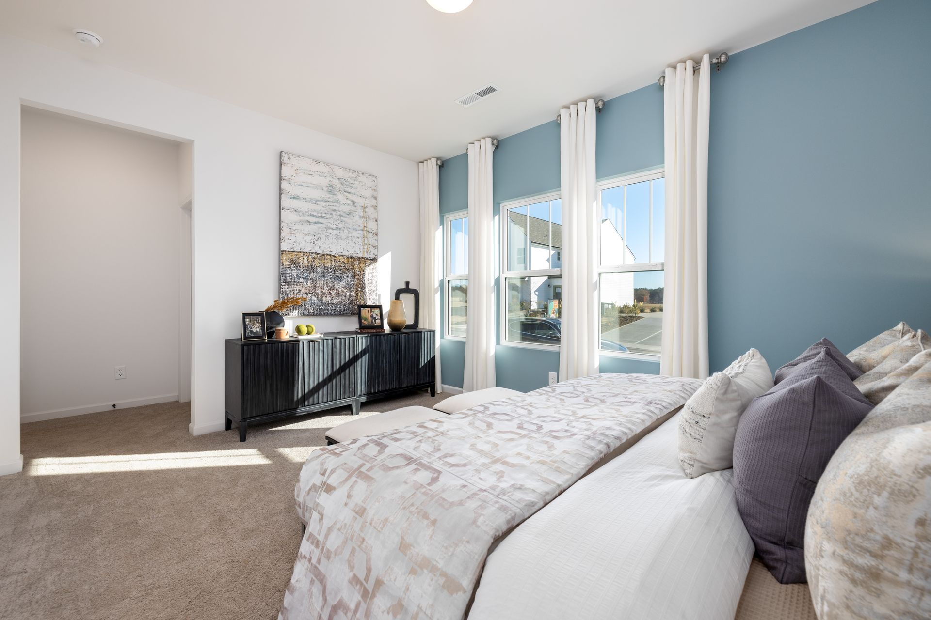 A bedroom with a large bed and blue walls.