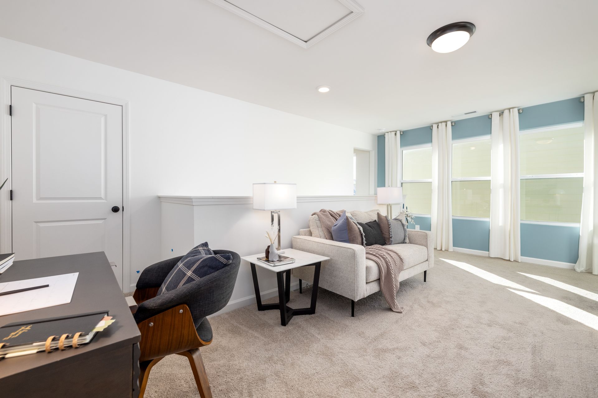 A living room with a couch , desk and chair.