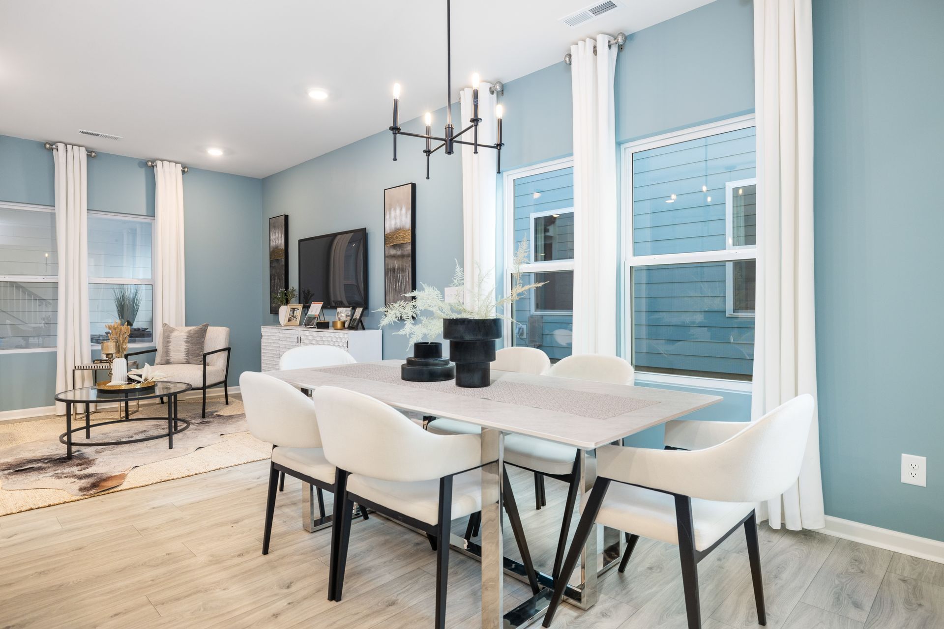 A dining room with a table and chairs and a chandelier.
